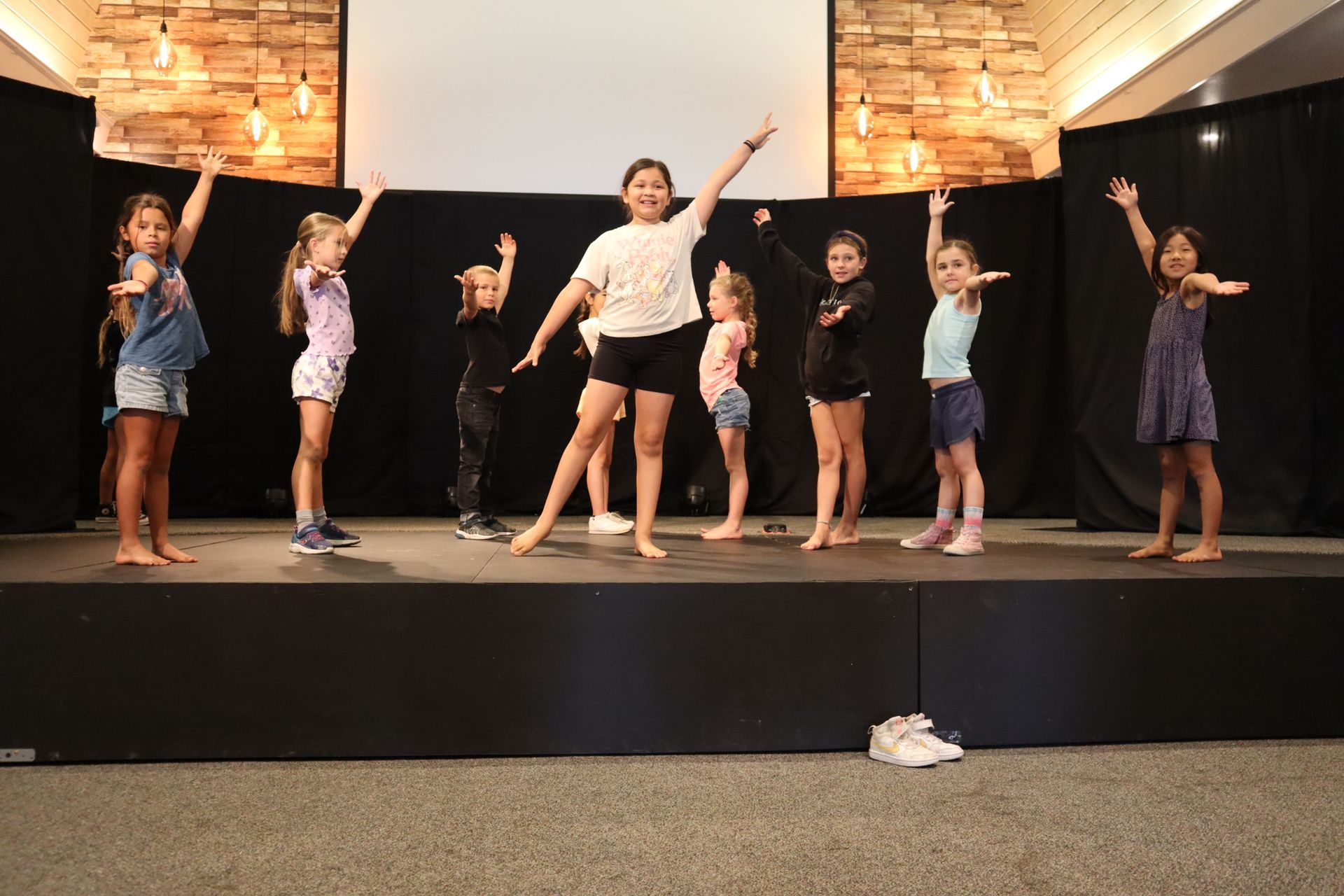 A group of young girls are dancing on a stage.