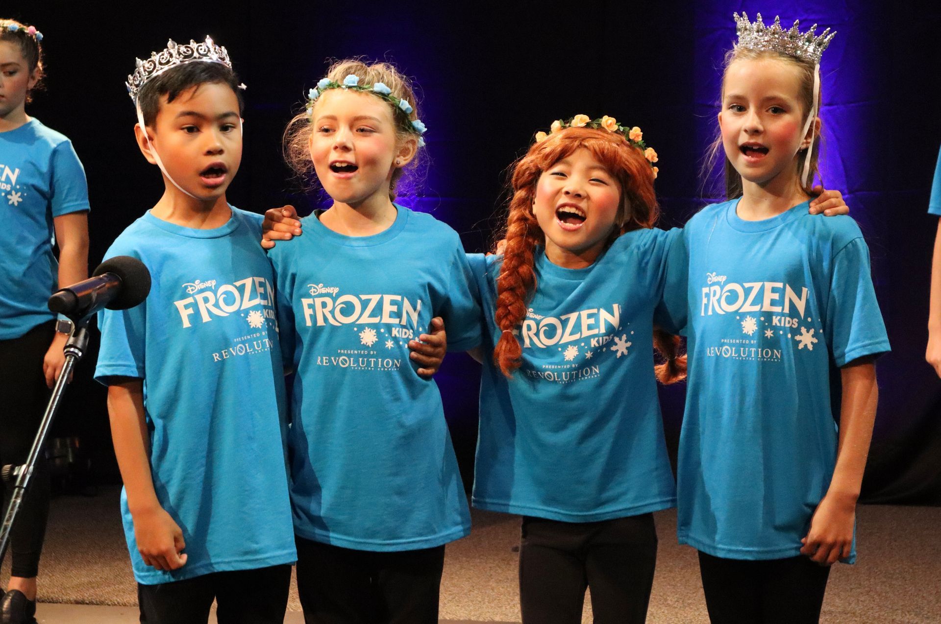 A group of young girls wearing blue frozen shirts