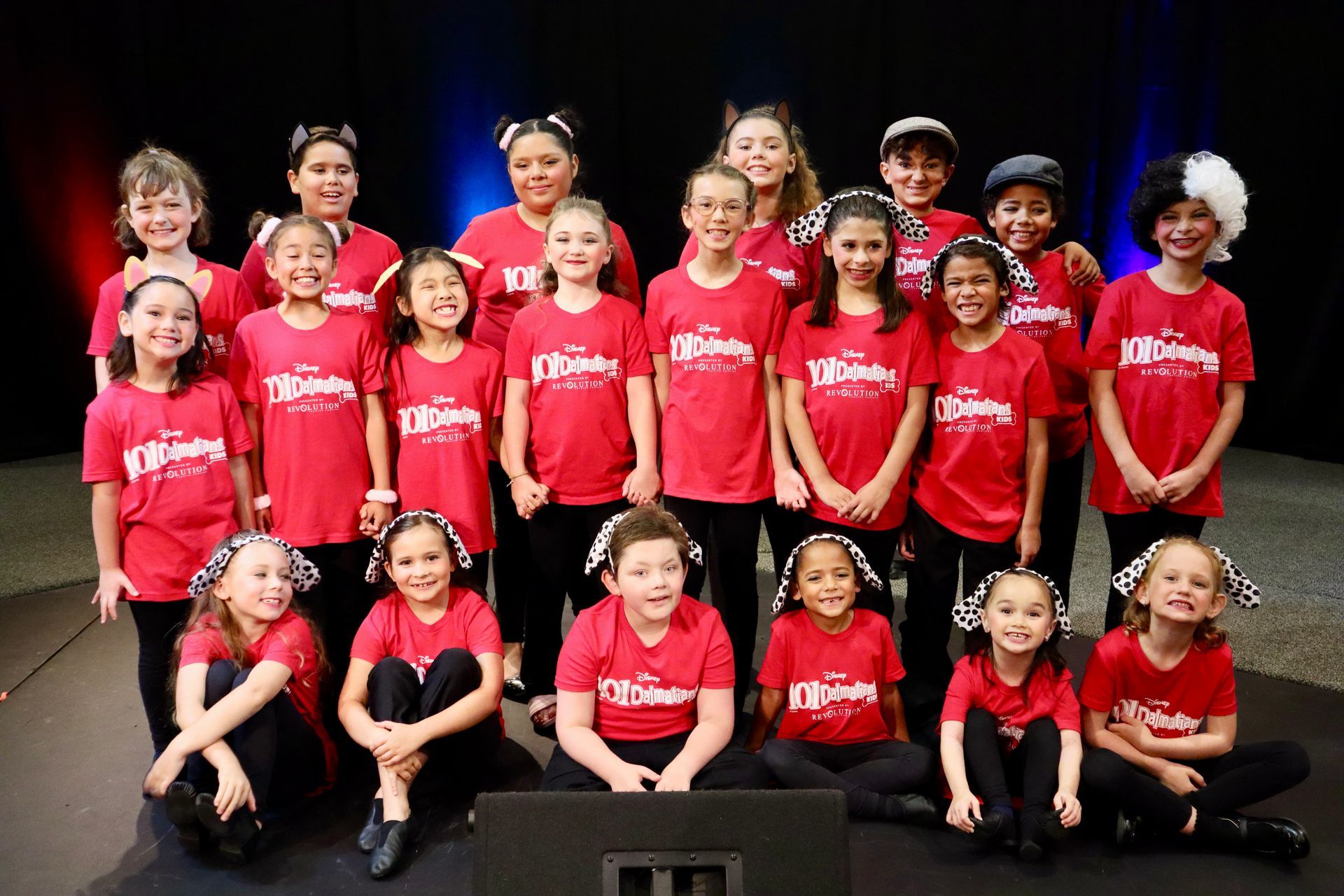 A group of young children wearing red shirts are posing for a picture.