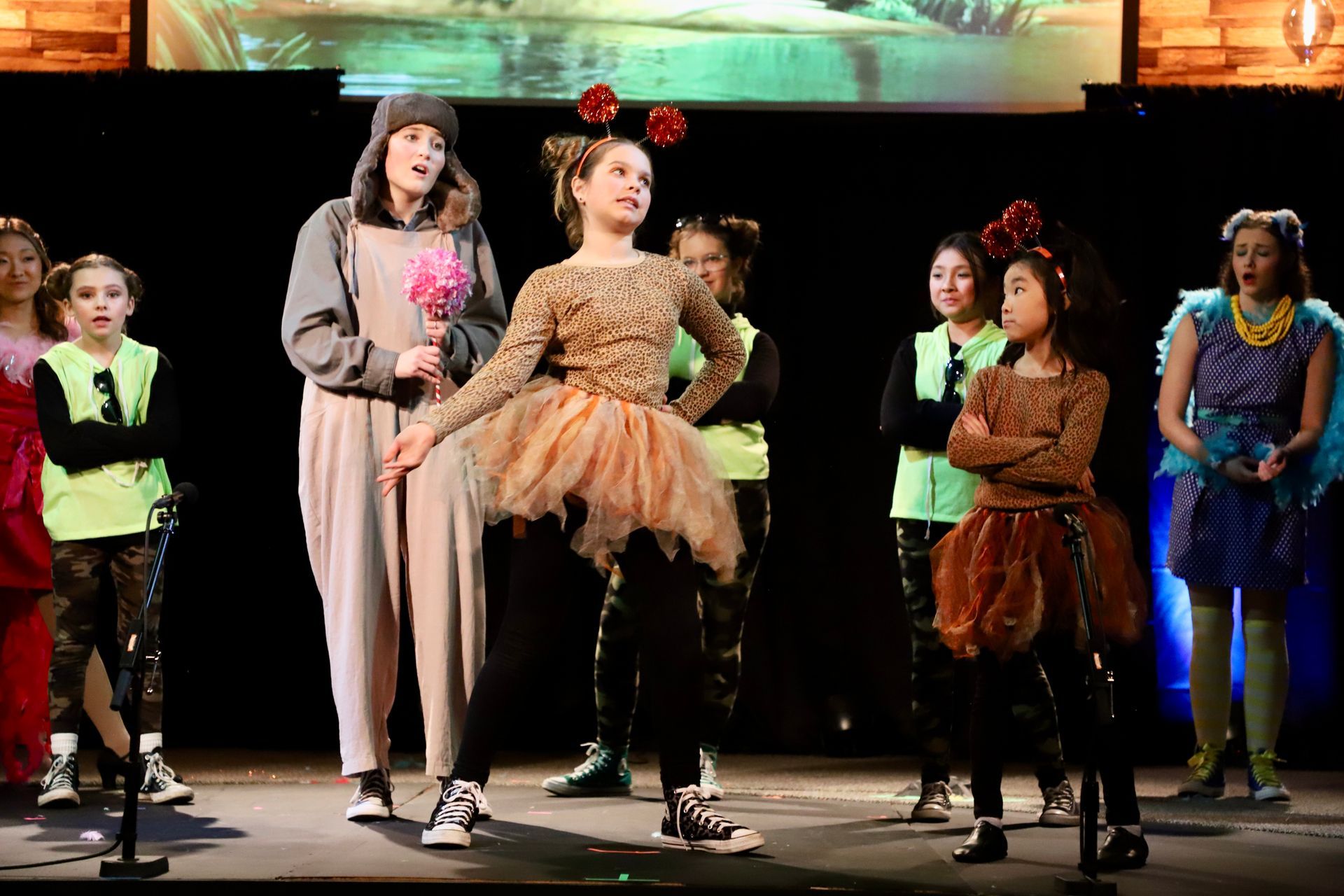 A group of children are standing on a stage in costumes.