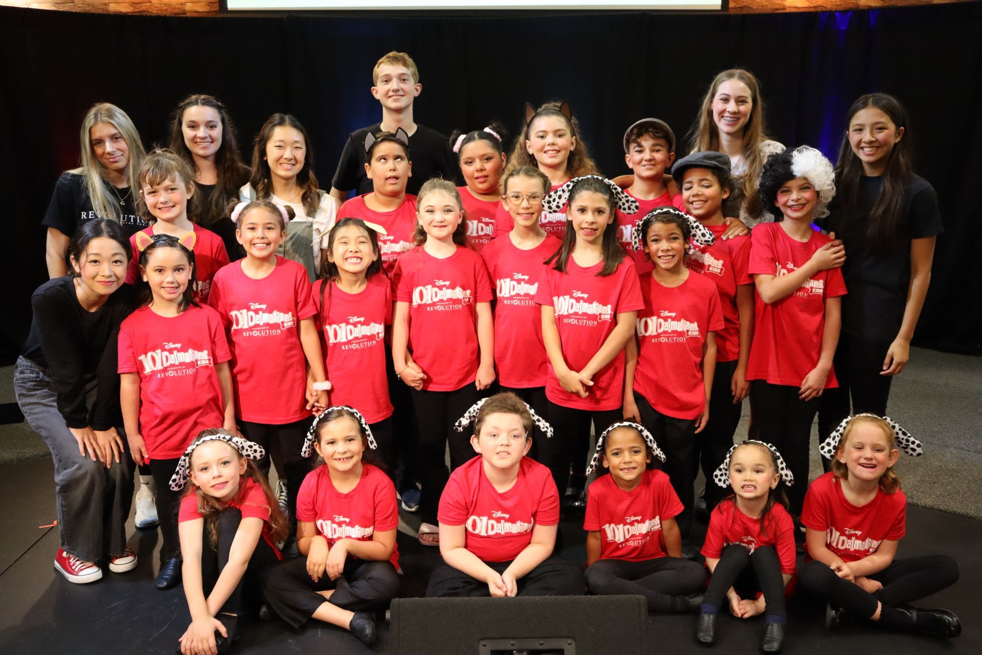 A group of children wearing red shirts are posing for a picture.
