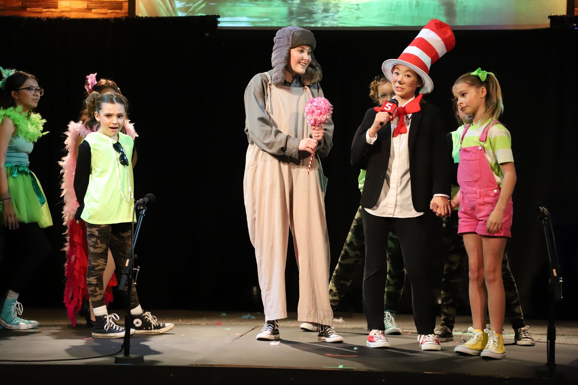 A group of children dressed in costumes are standing on a stage.