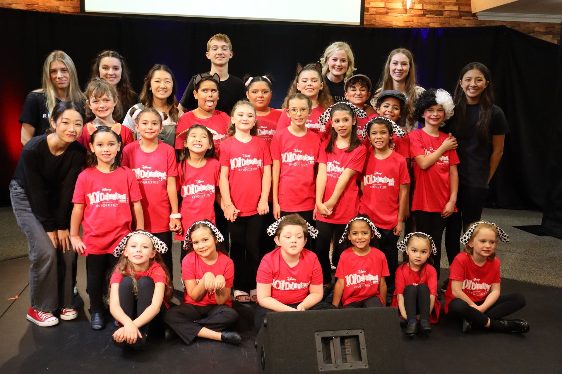 A group of children in red shirts are posing for a picture.