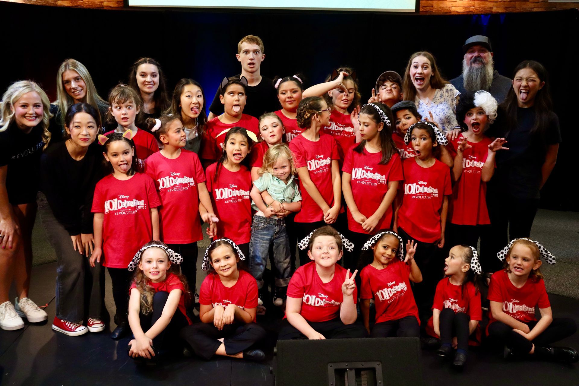 A group of children wearing red shirts are posing for a picture.