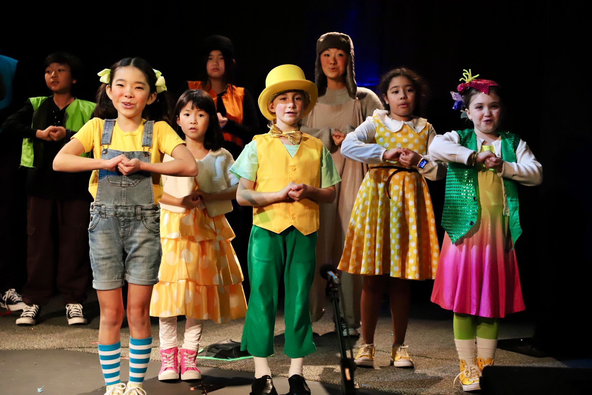 A group of children are standing next to each other on a stage.