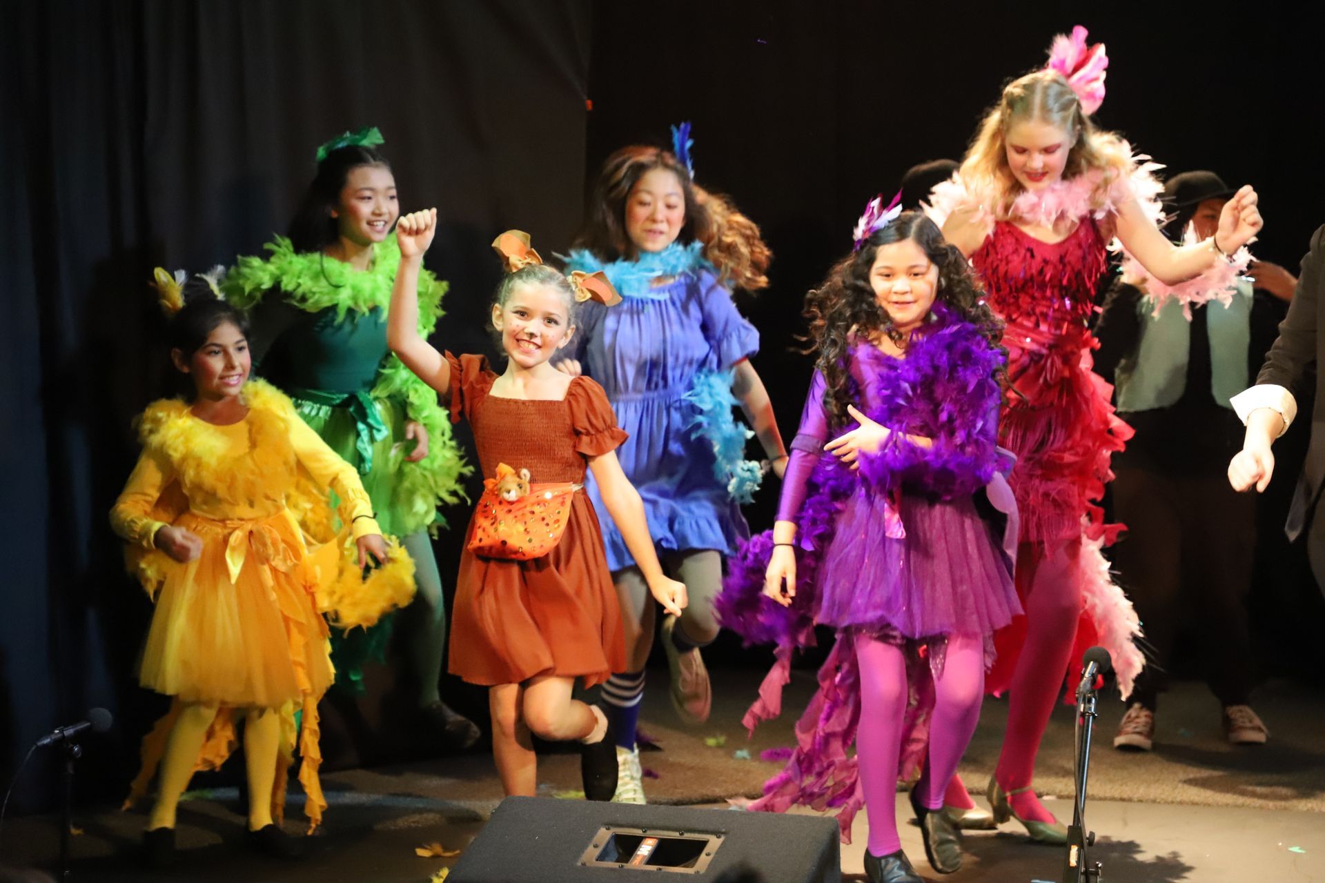 A group of young girls are dancing on a stage.