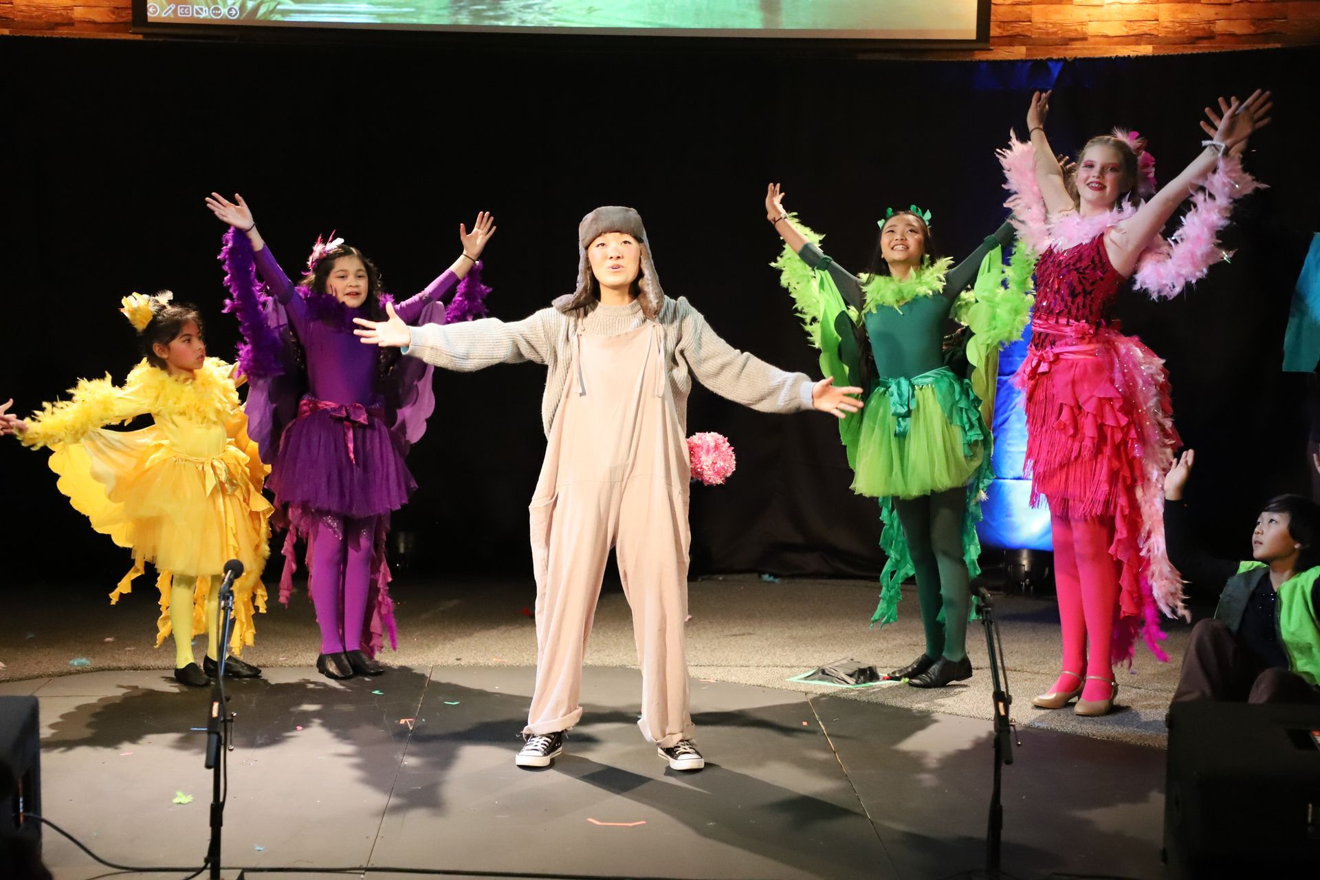A group of people in colorful costumes are dancing on a stage.