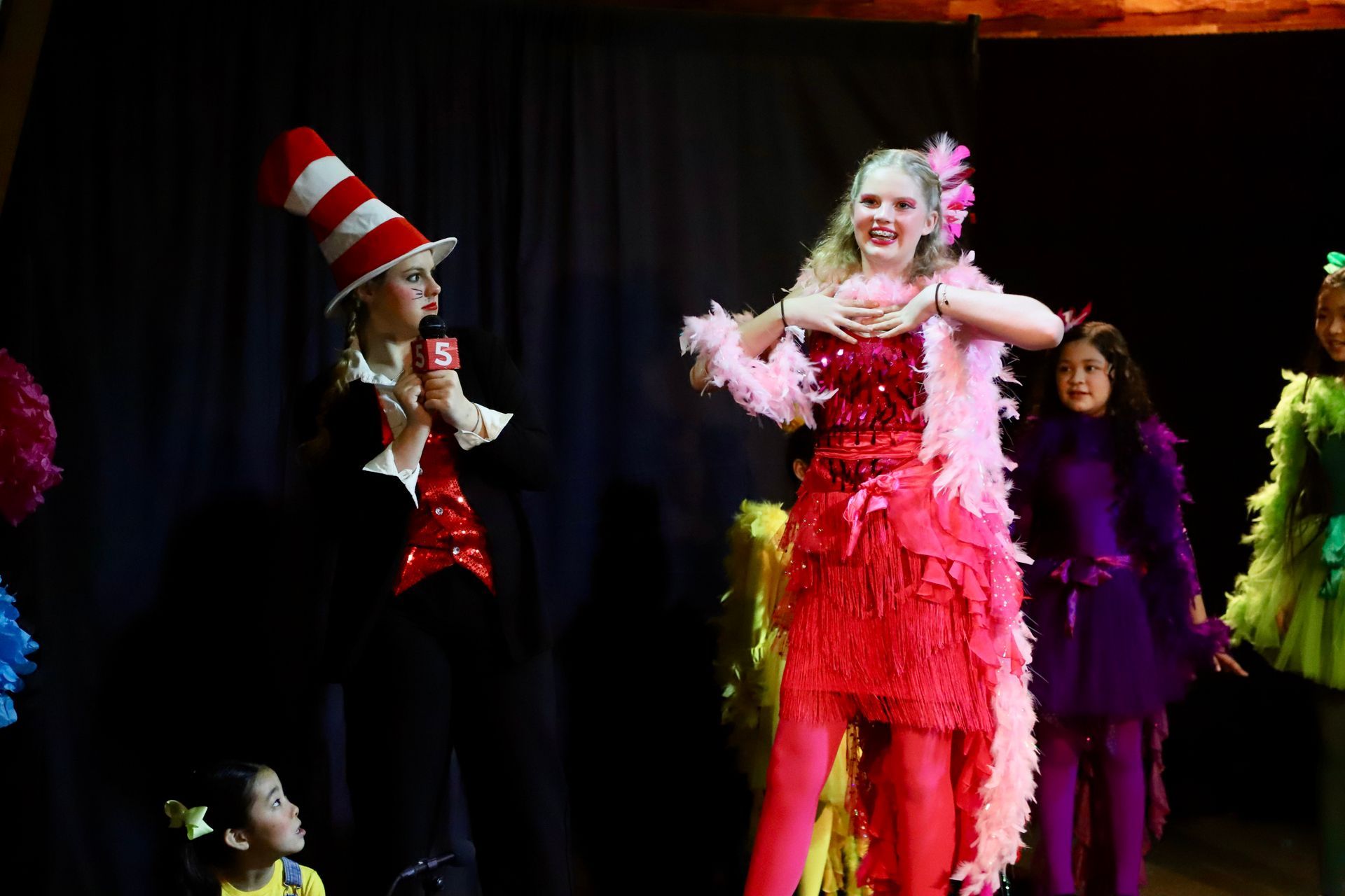 A group of children dressed in costumes are standing on a stage.