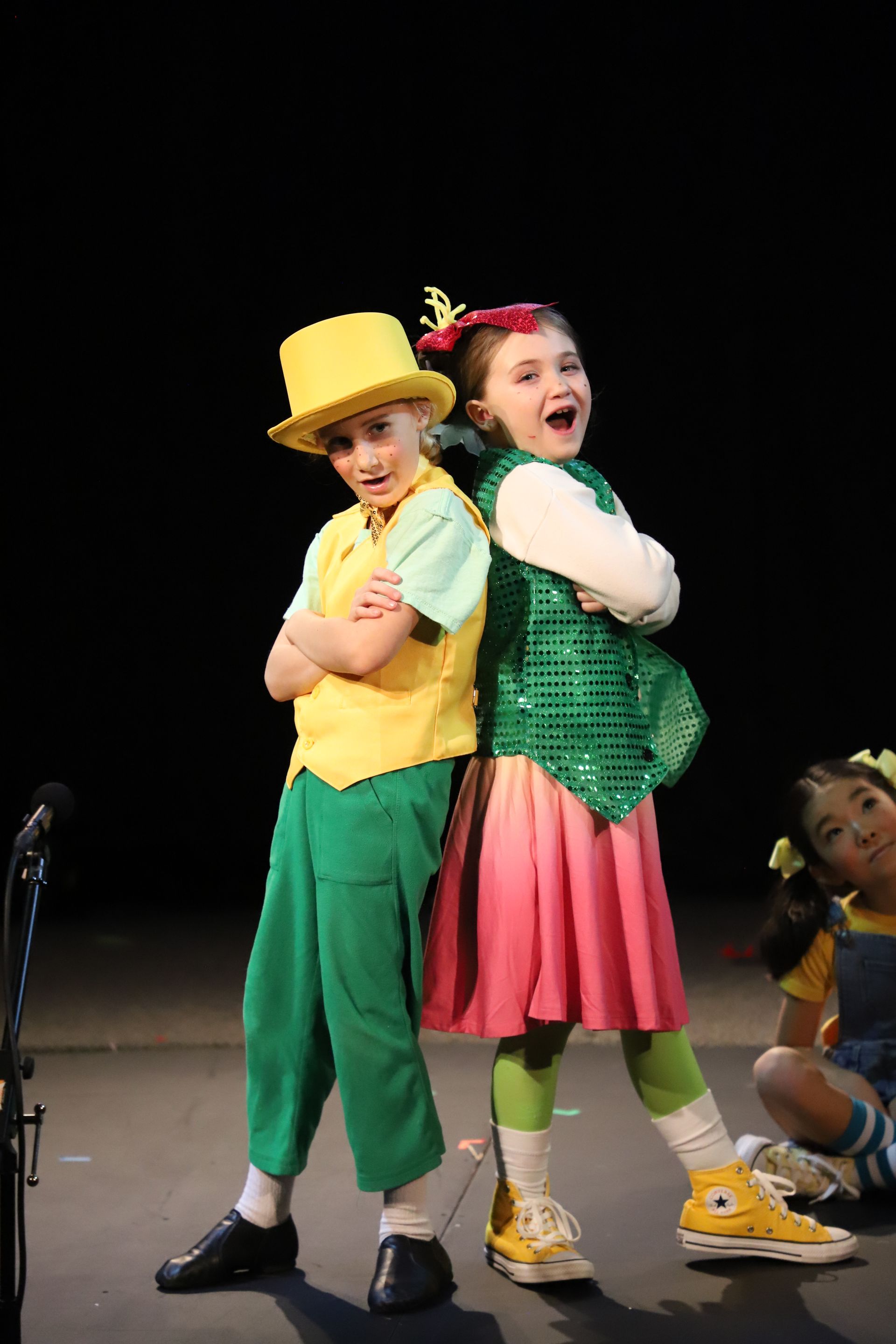 A boy and a girl are standing next to each other on a stage.