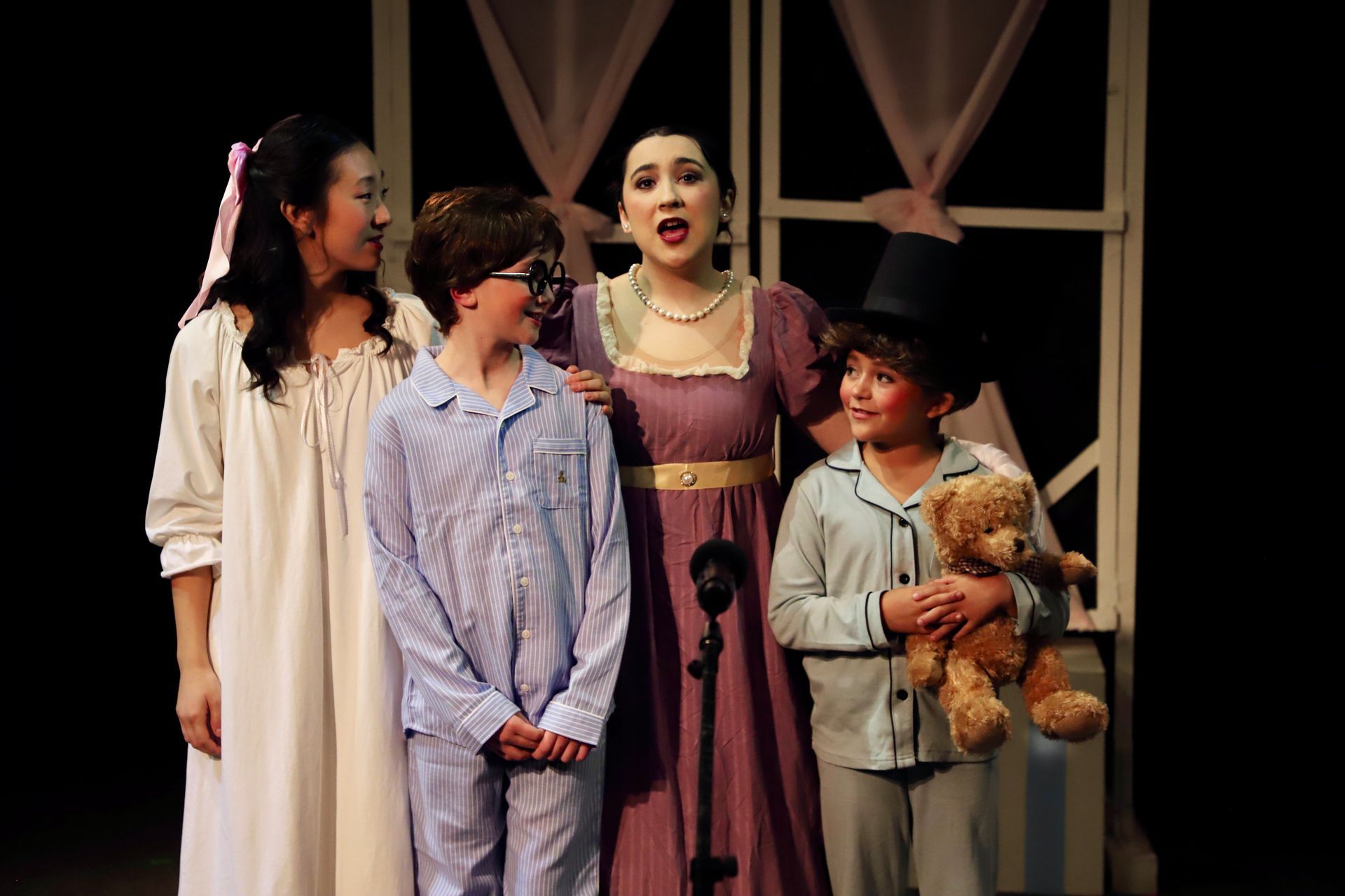 A group of children are standing next to each other on a stage.