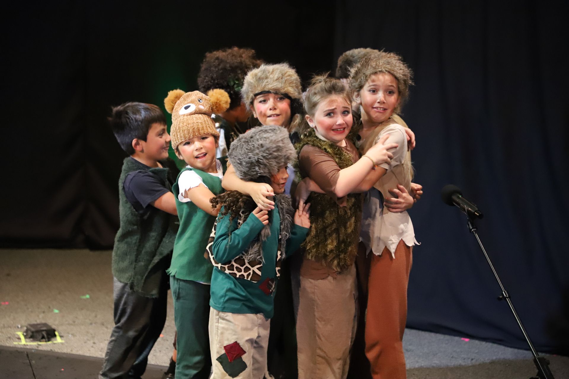 A group of children are posing for a picture on a stage.