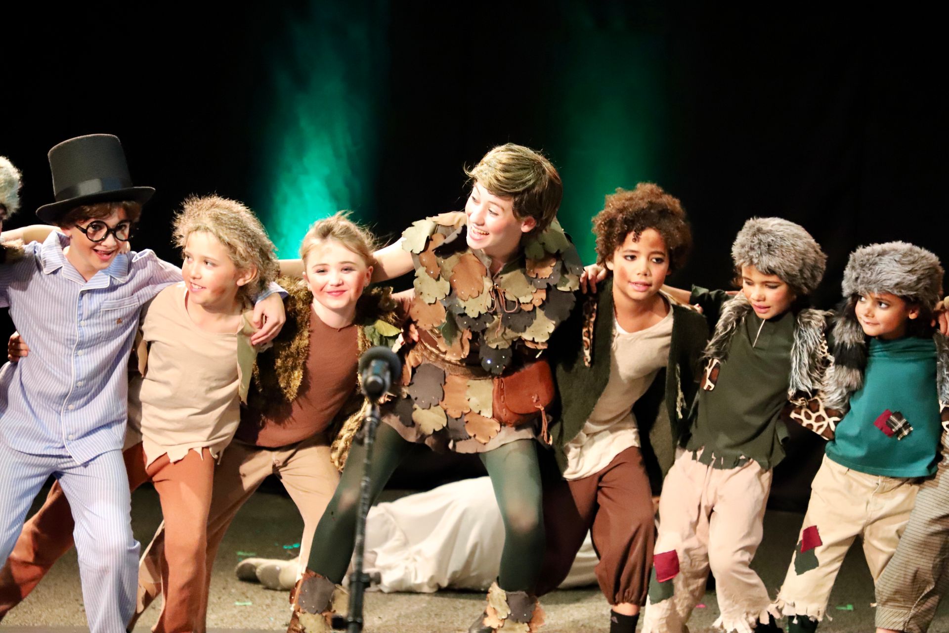 A group of children are standing next to each other on a stage.