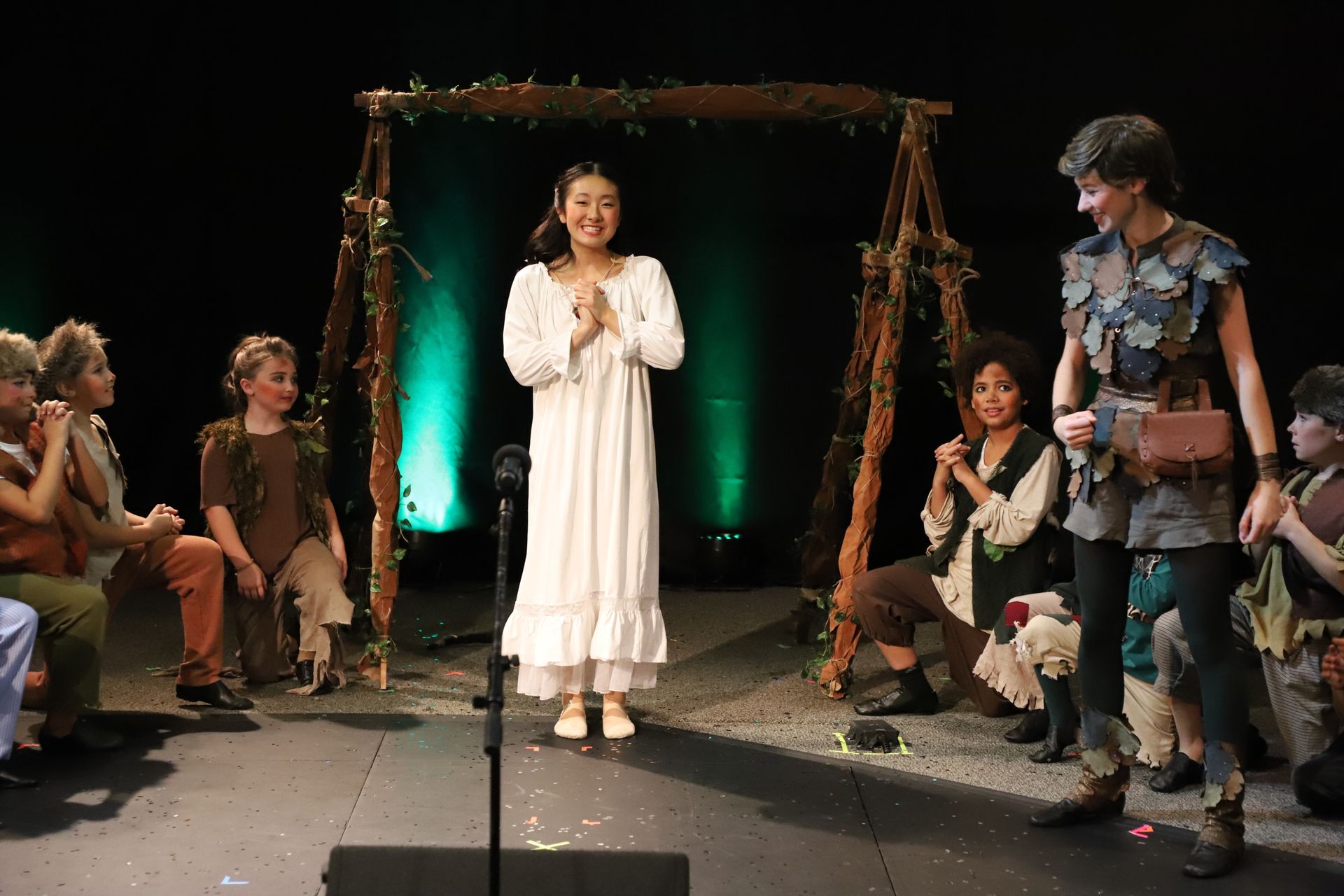 A group of children are playing peter pan on a stage.