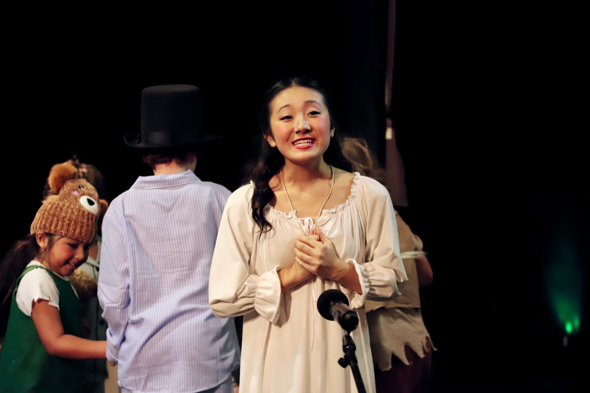 A woman is standing in front of a microphone on a stage.