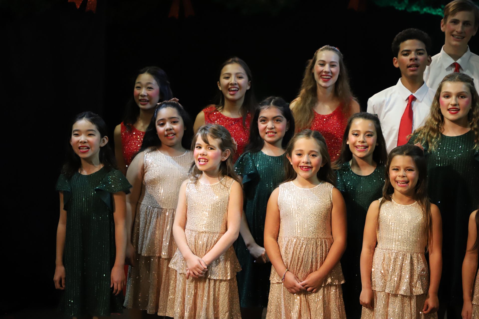 A group of young girls are posing for a picture on a stage.