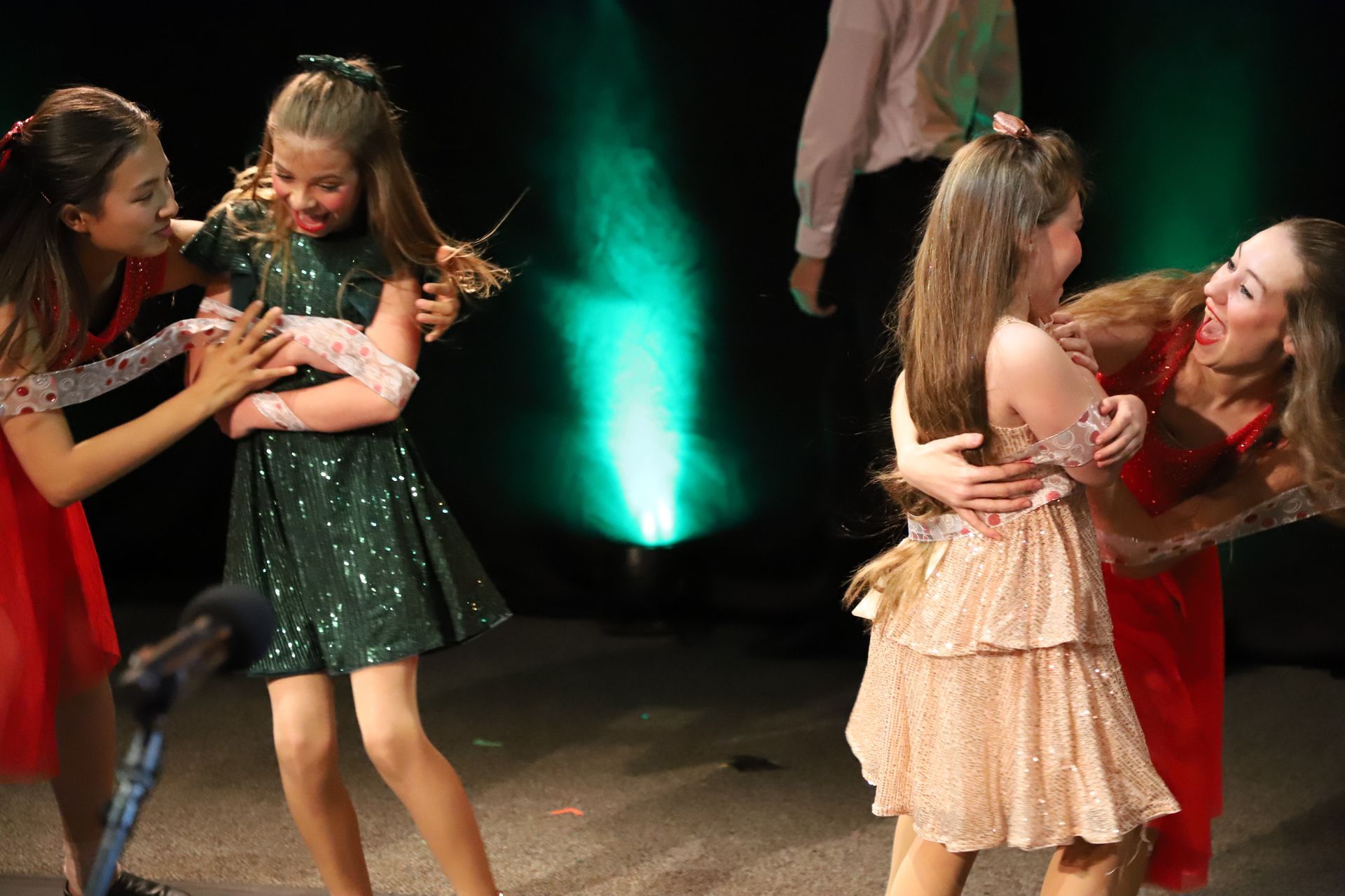 A group of young girls are dancing on a stage.