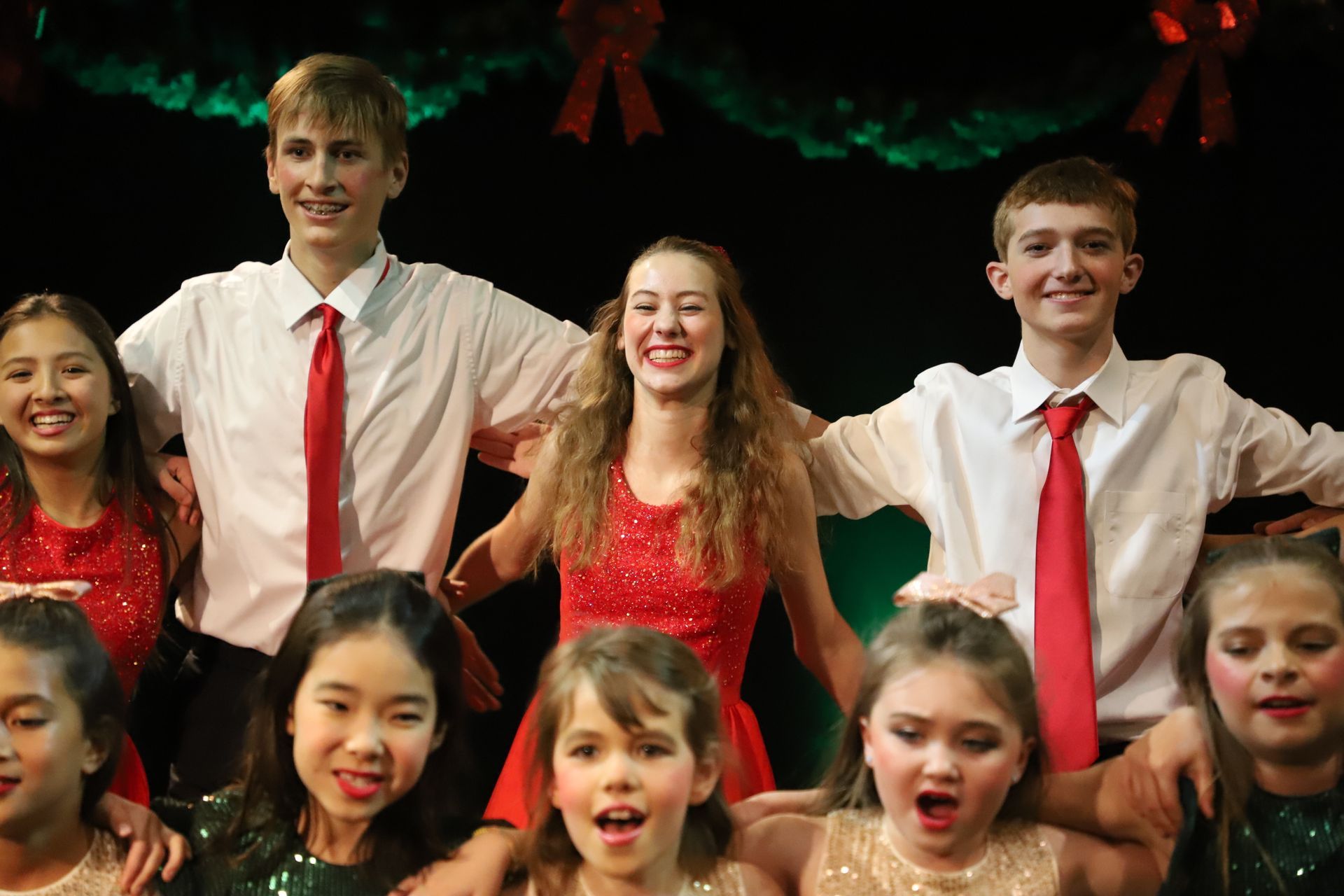 A group of young people are posing for a picture on a stage.