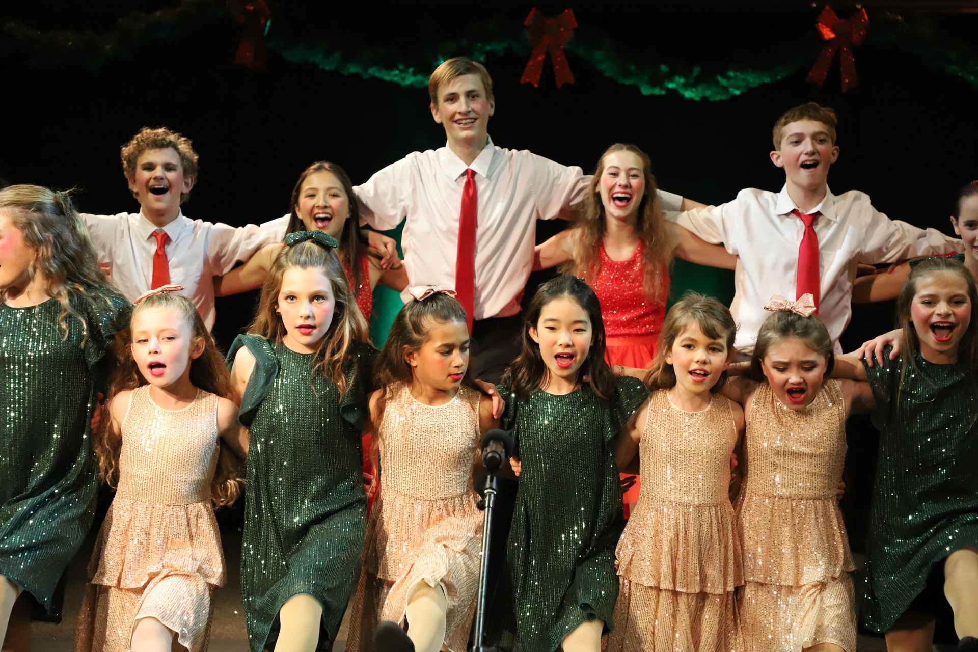 A group of children are posing for a picture on a stage.