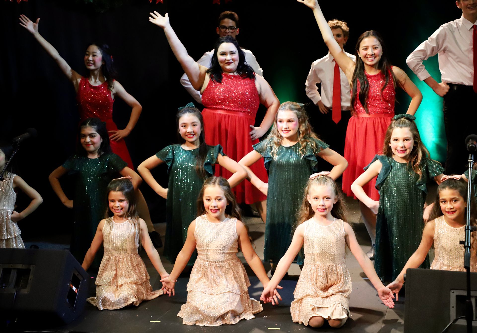 A group of young girls are posing for a picture on a stage.