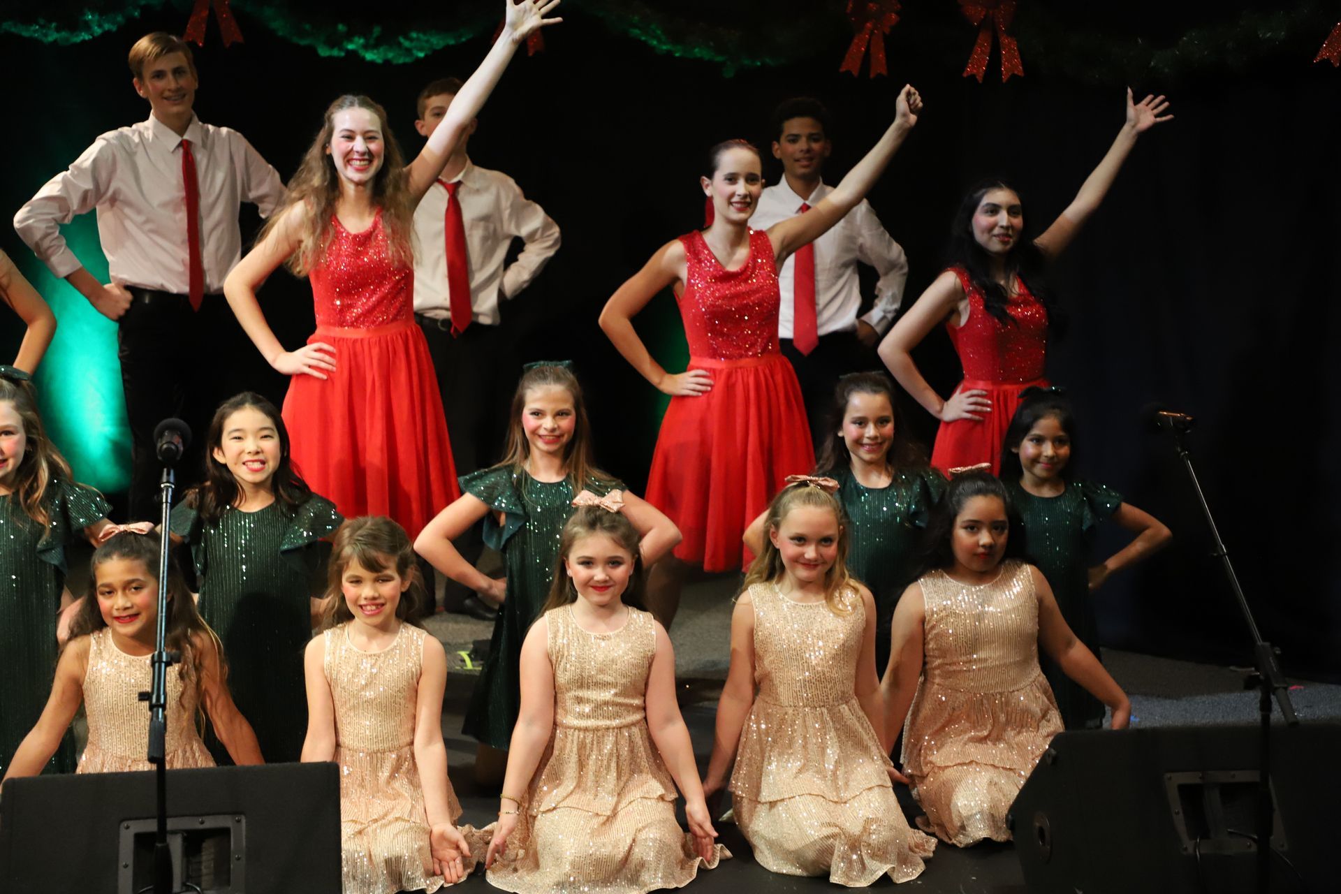A group of young girls are posing for a picture on a stage.