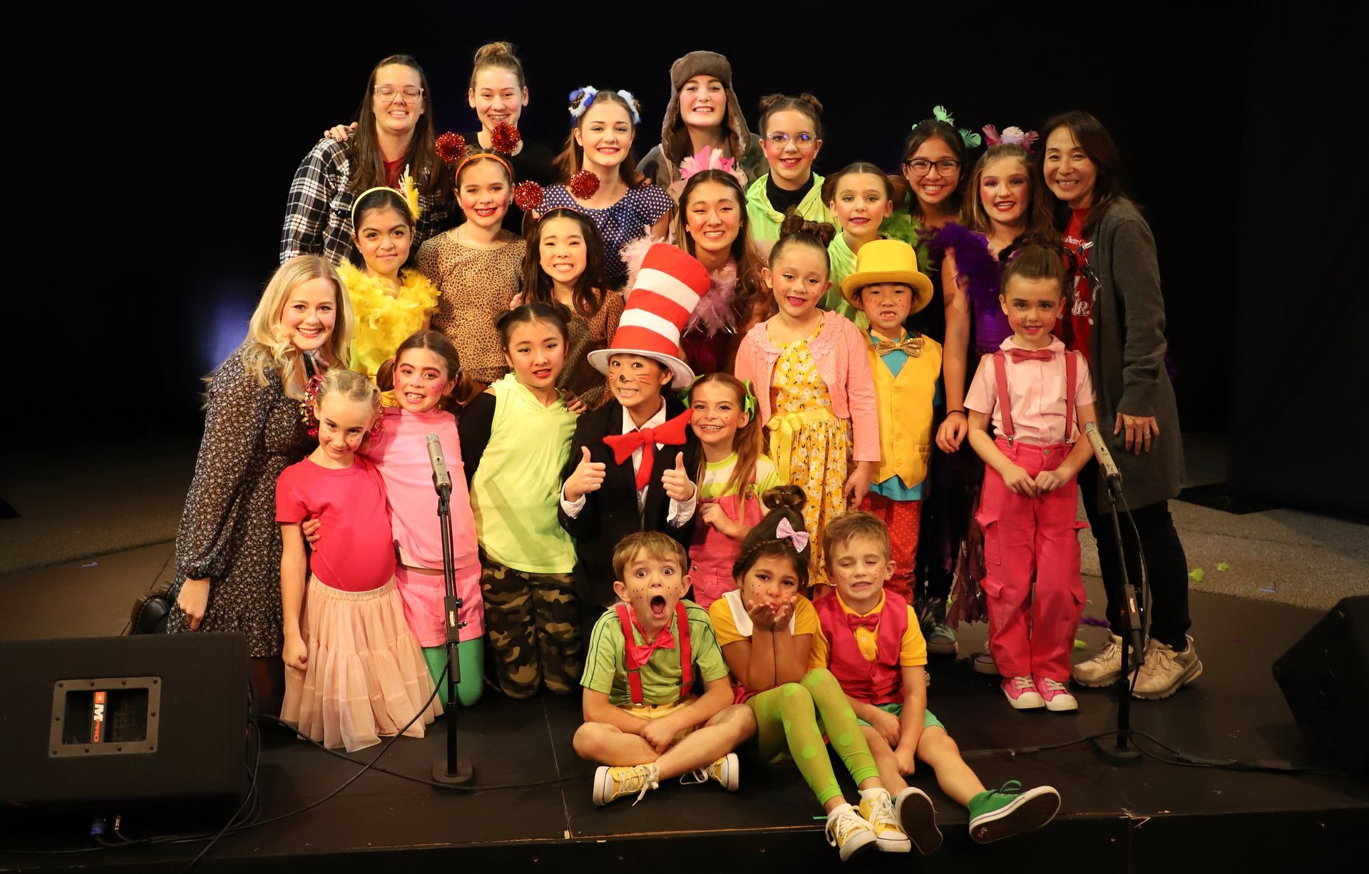 A group of children are posing for a picture on a stage.
