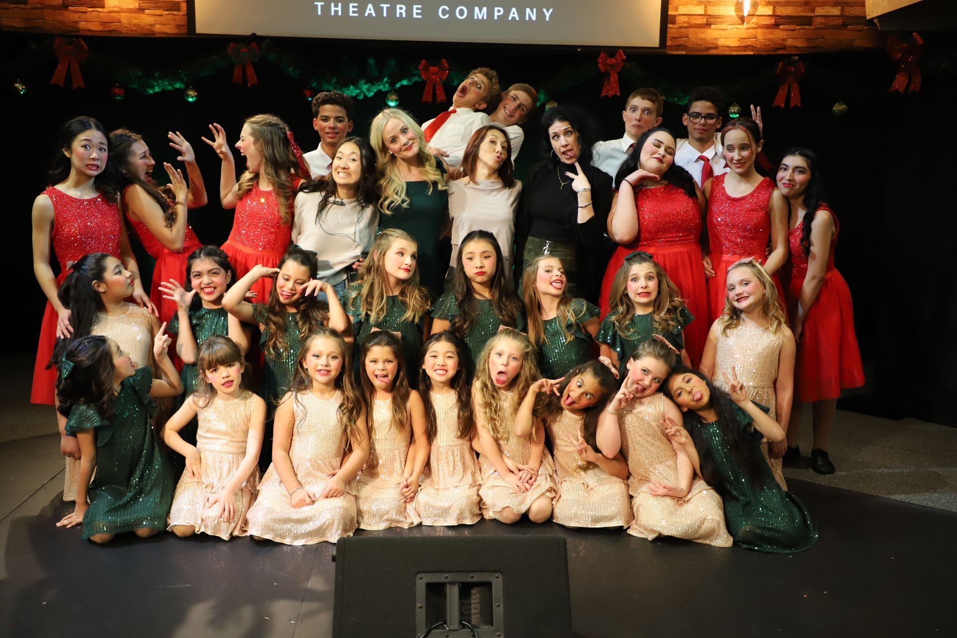 A group of children are posing for a picture on a stage.