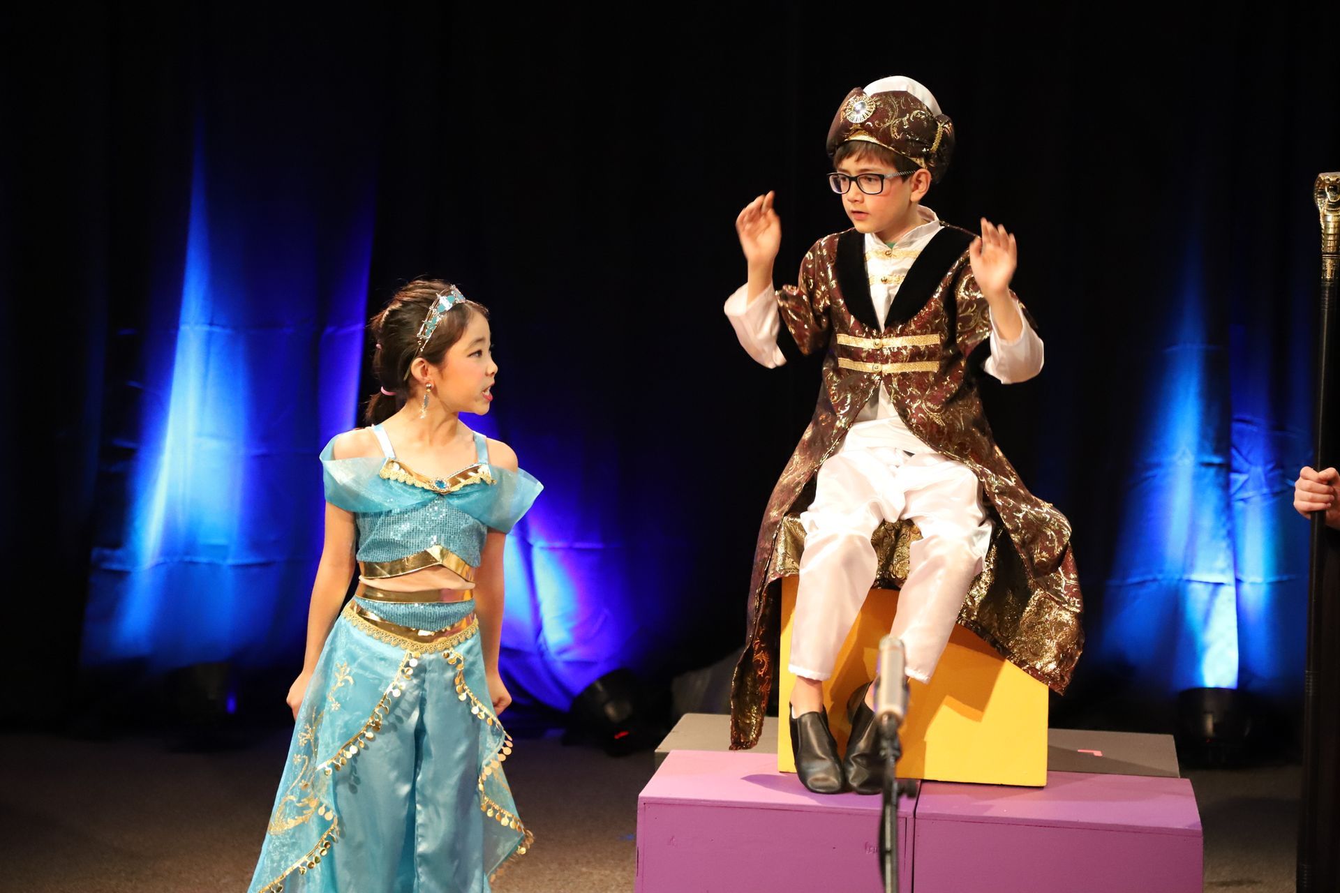 A boy and a girl are standing next to each other on a stage.