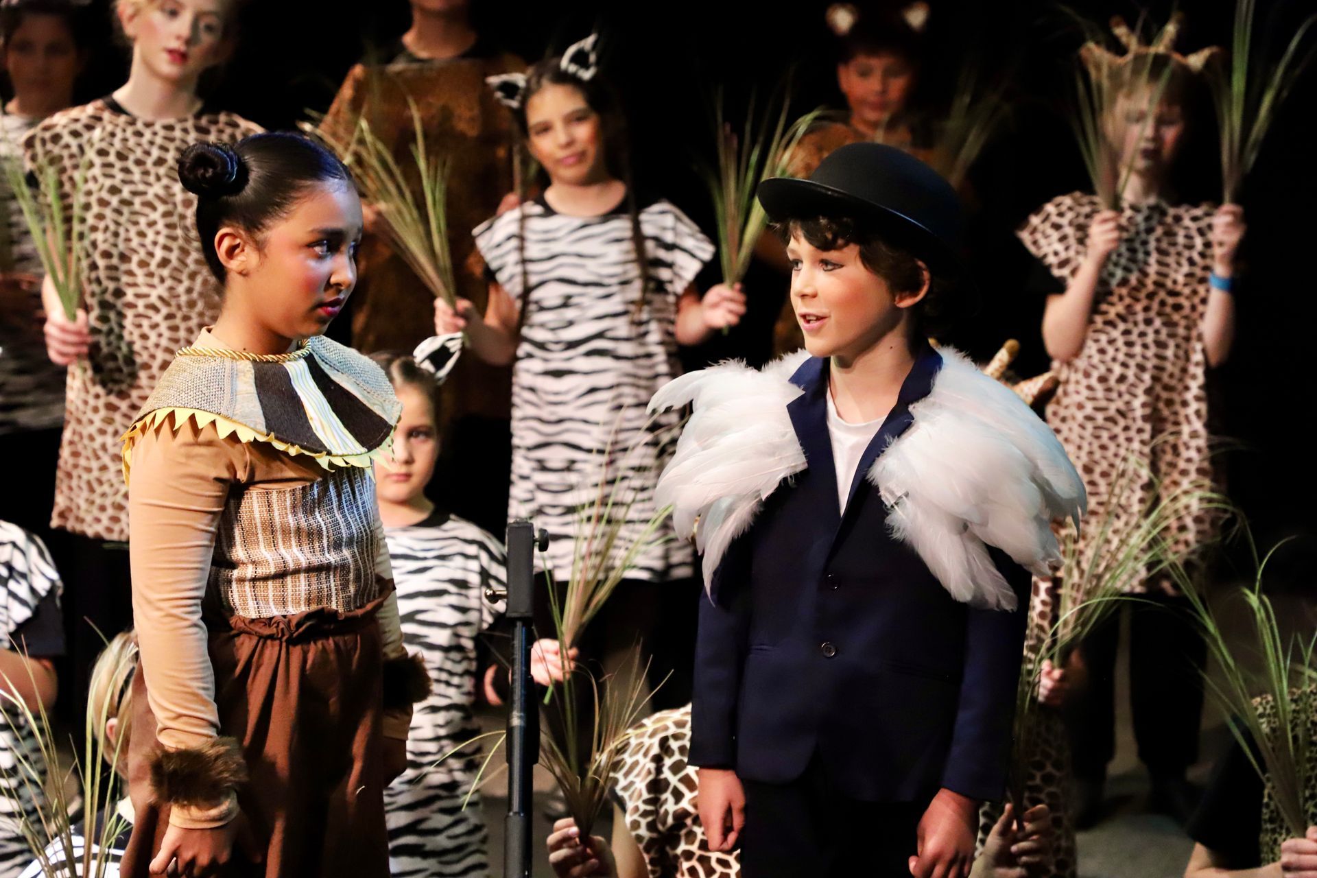 A boy and a girl are standing next to each other in front of a microphone.