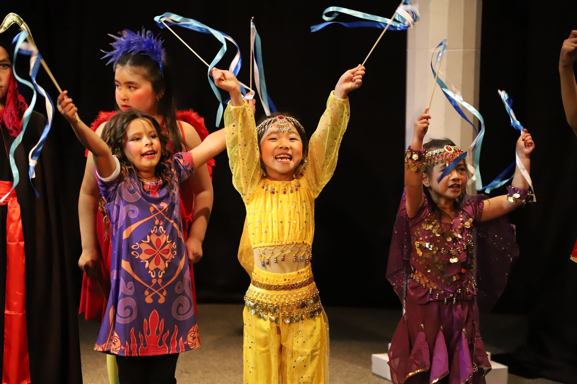 A group of young girls are holding ribbons in their hands