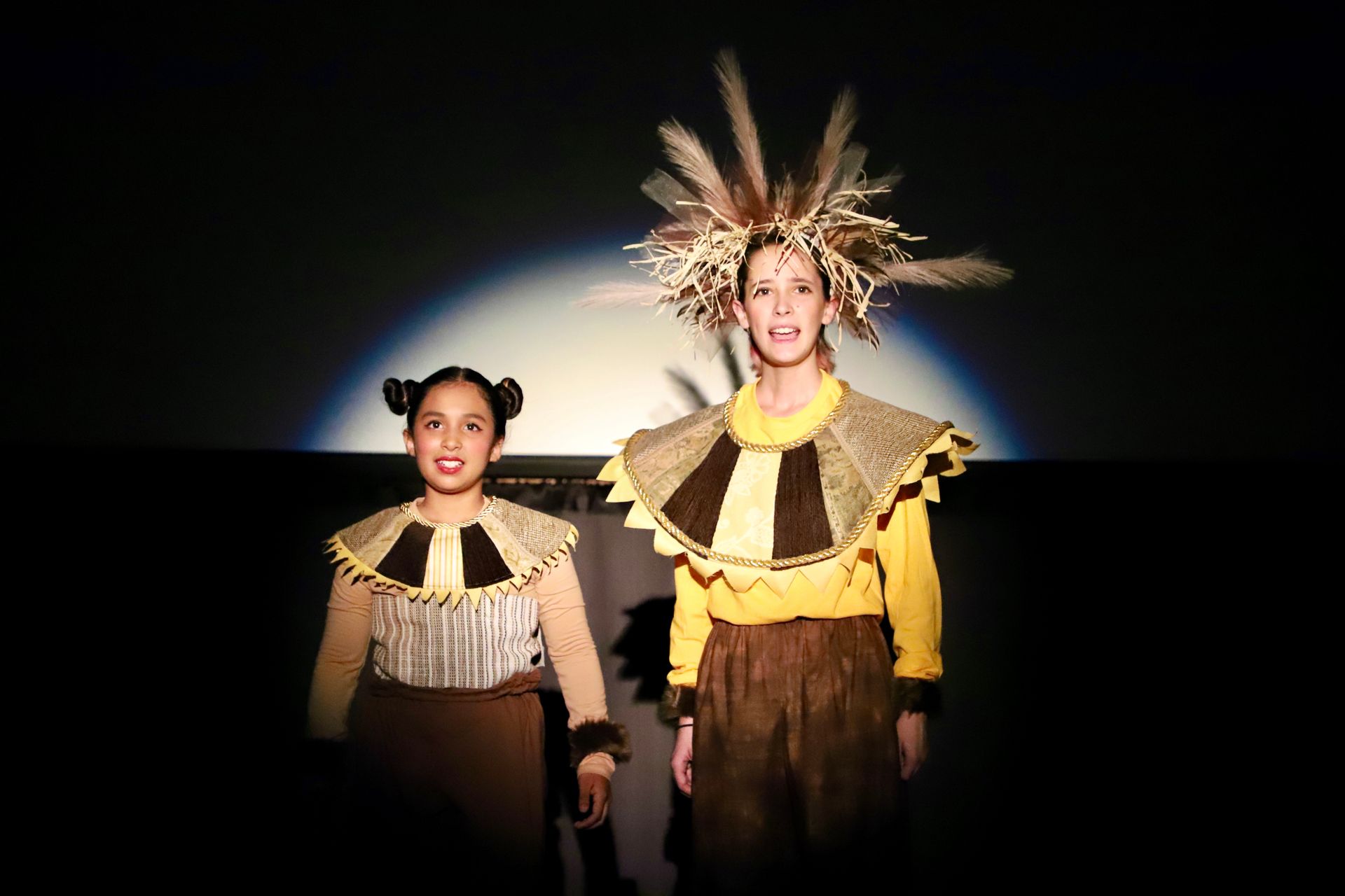 Two people in costume are standing next to each other on a stage.