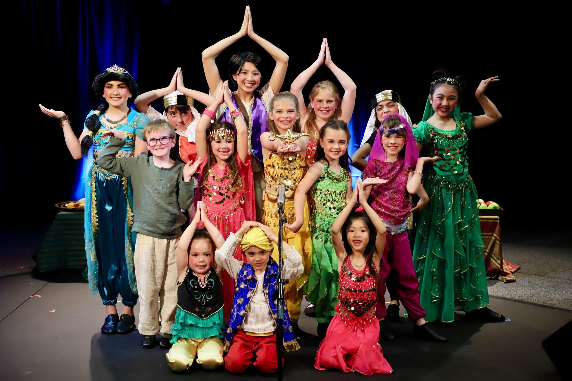 A group of children are posing for a picture on a stage.