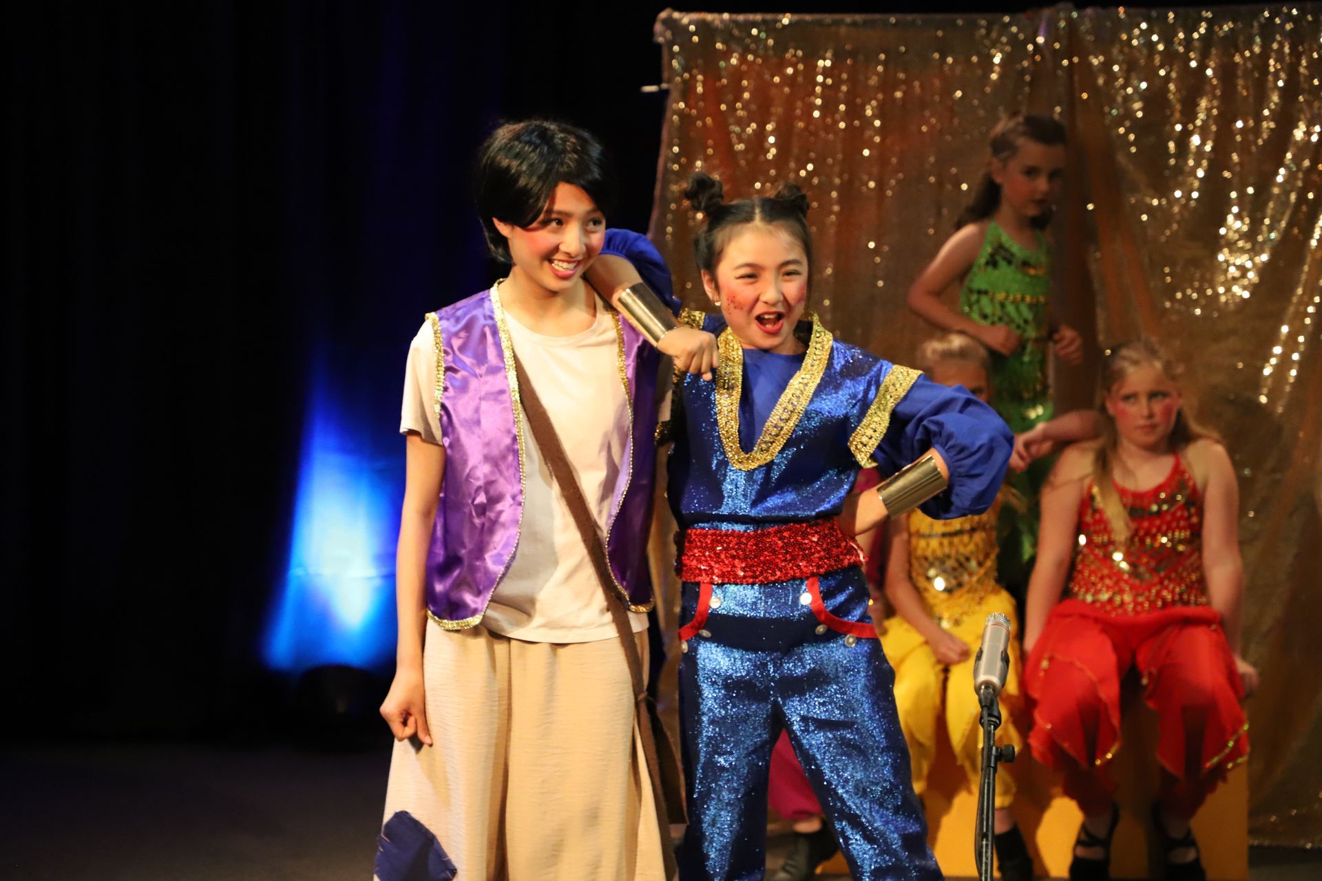 A boy and a girl are standing next to each other on a stage.