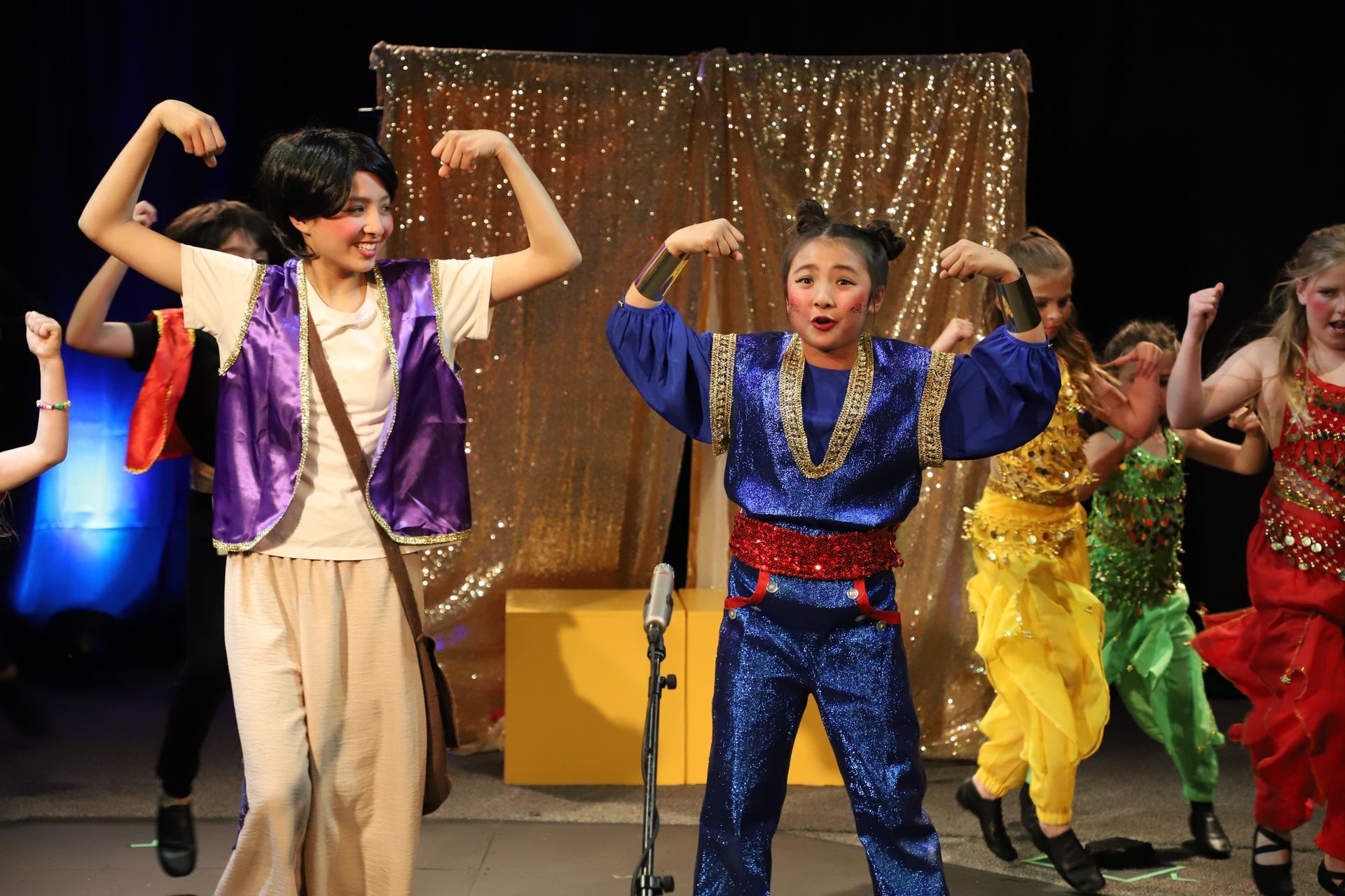 A group of children are dancing on a stage.
