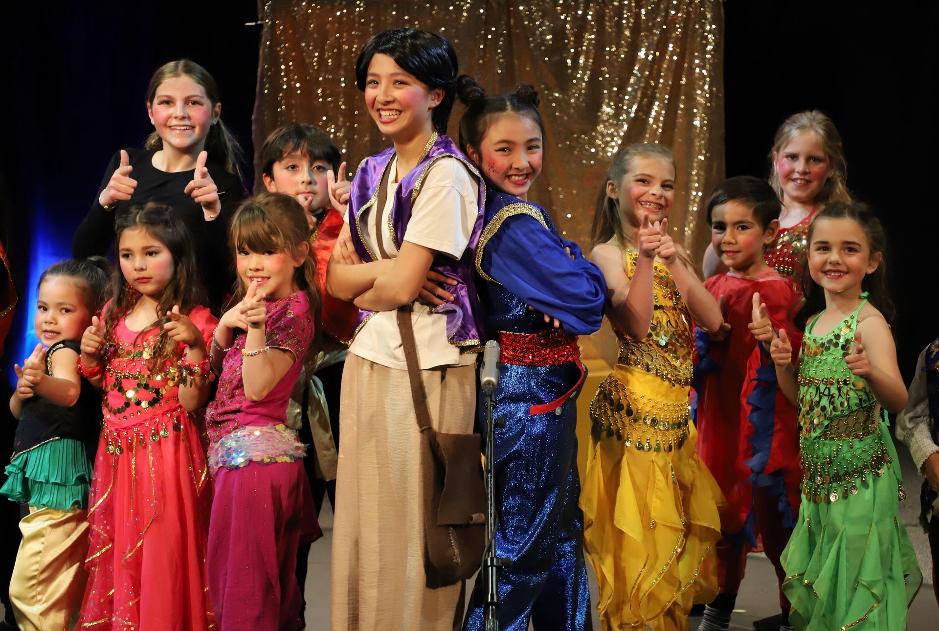A group of young girls are standing next to each other on a stage.