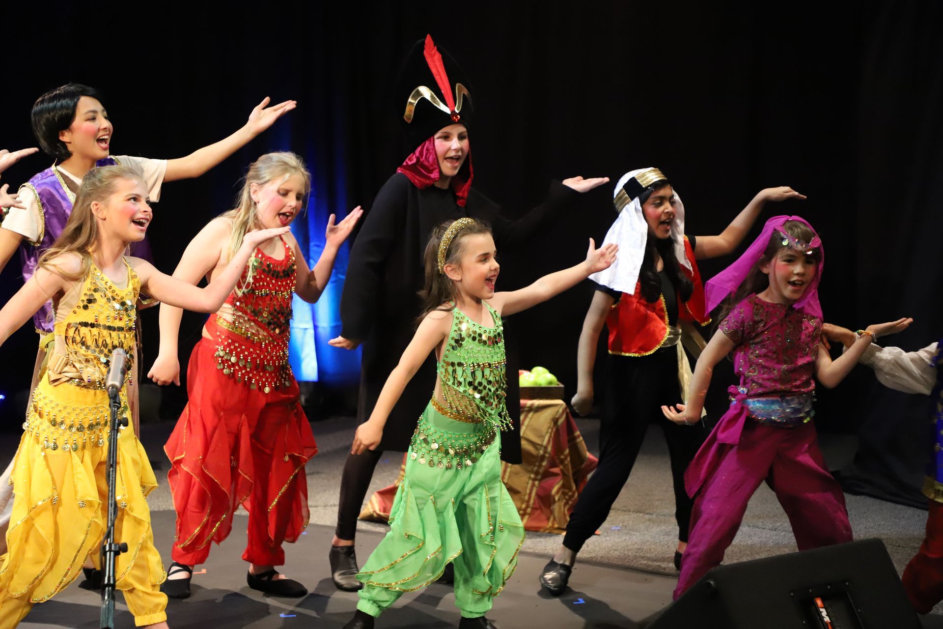 A group of young girls are dancing on a stage.