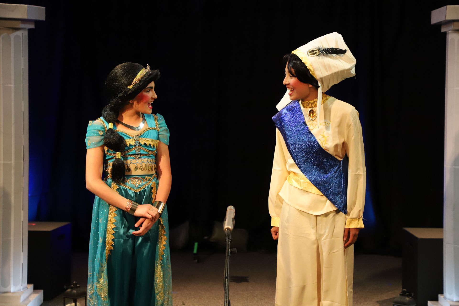 A man and a woman in costumes are standing next to each other on a stage.