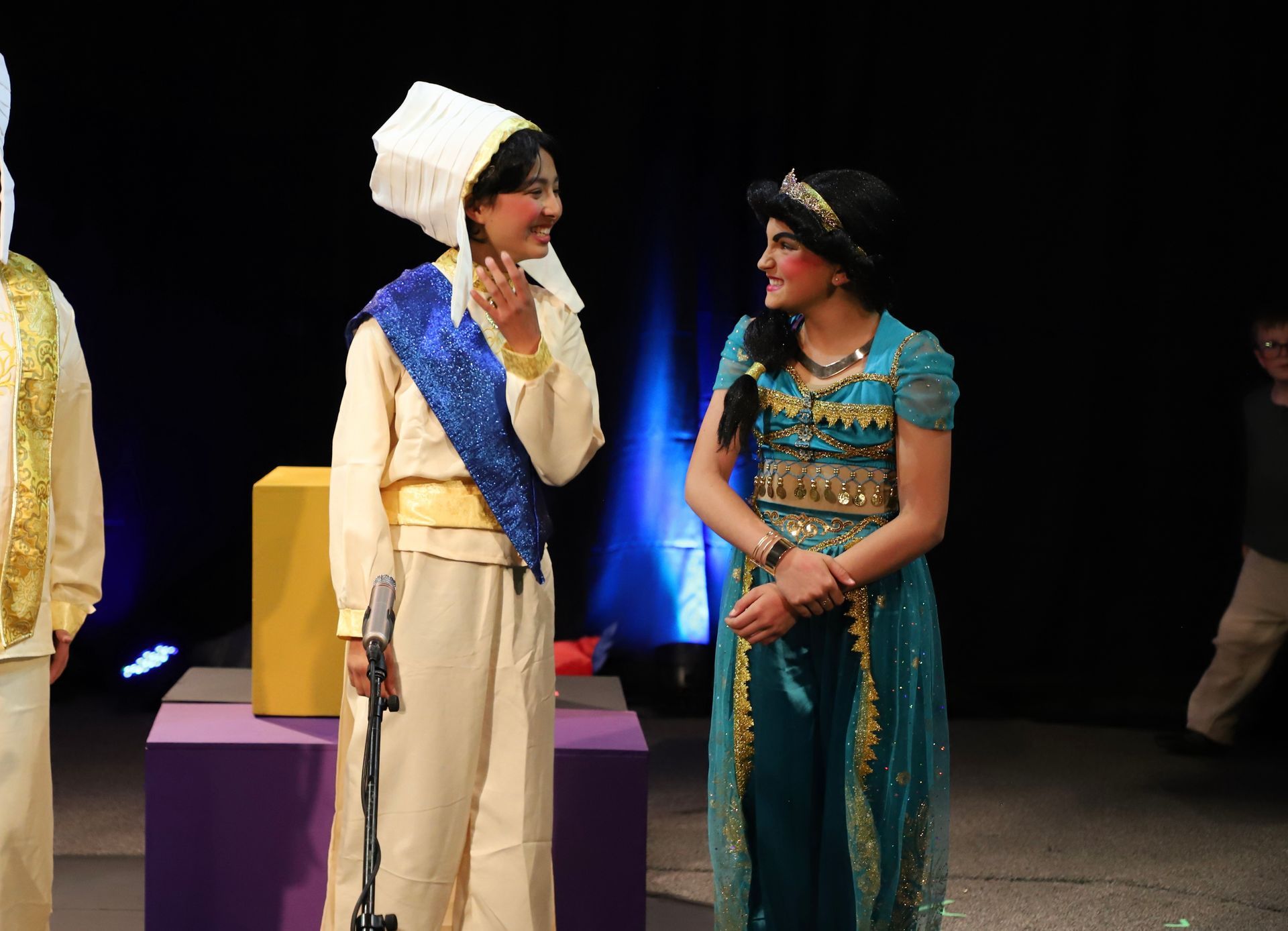 A man and a woman are standing next to each other on a stage.