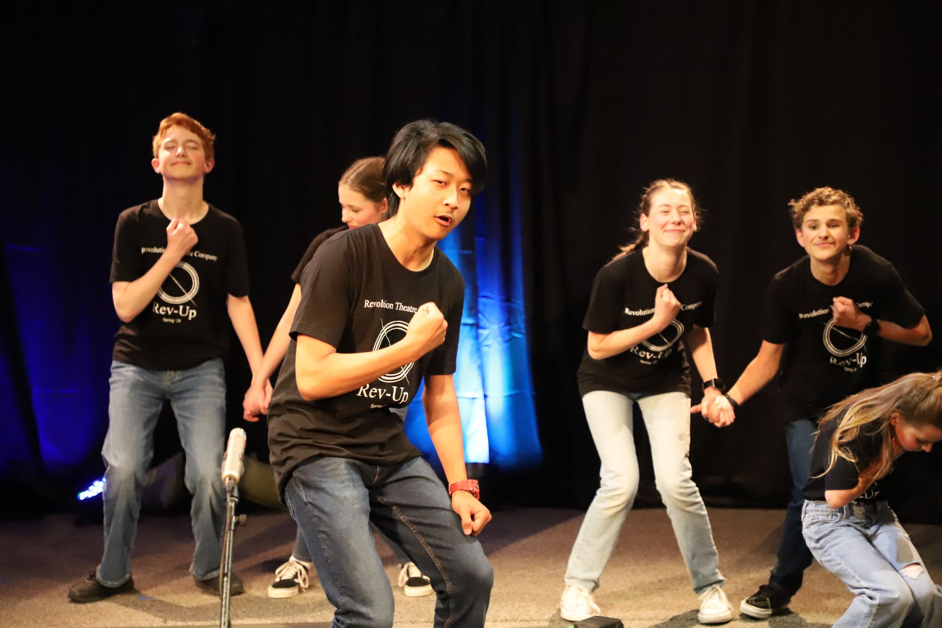 A group of young people are dancing on a stage.