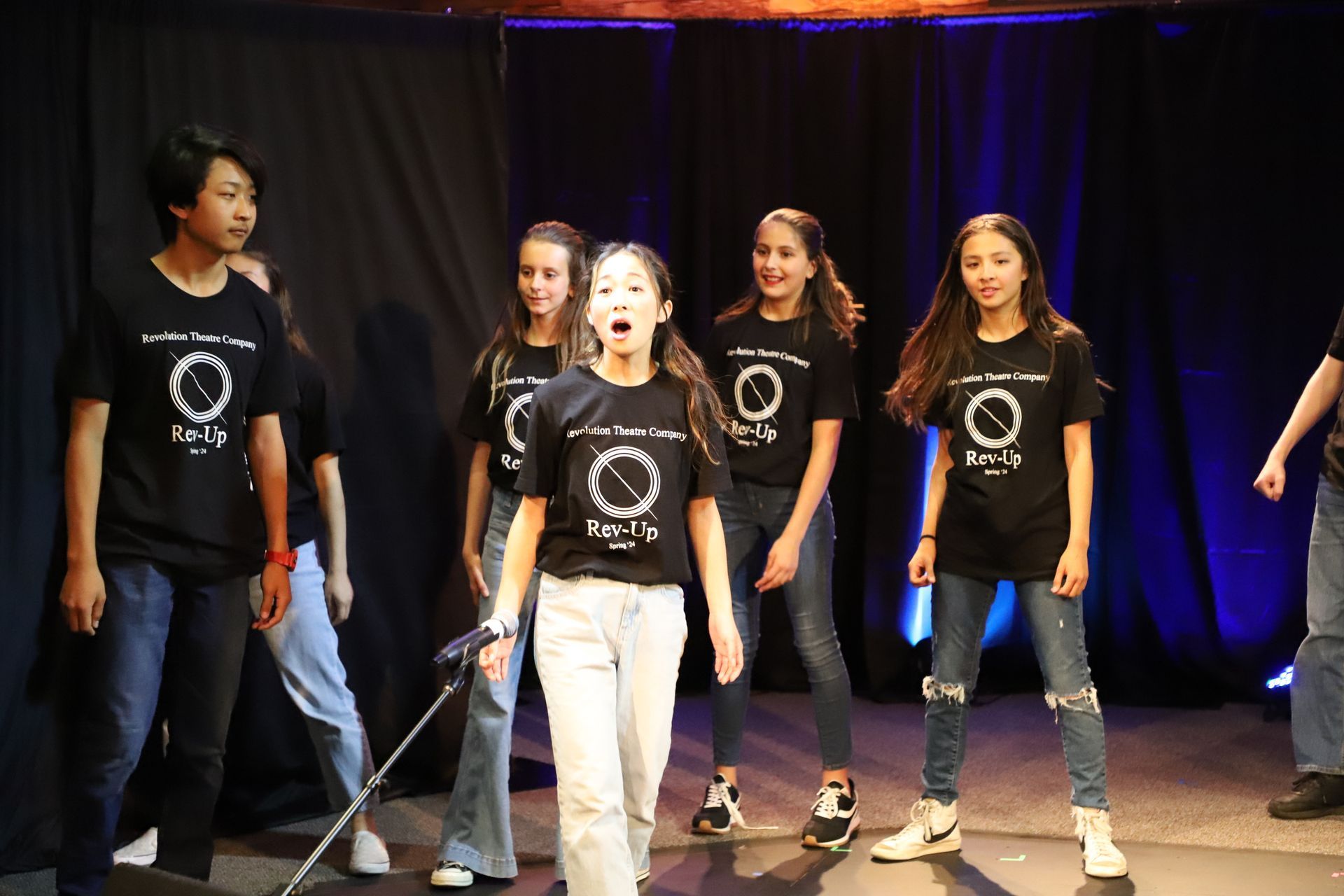 A group of young people are standing on a stage.