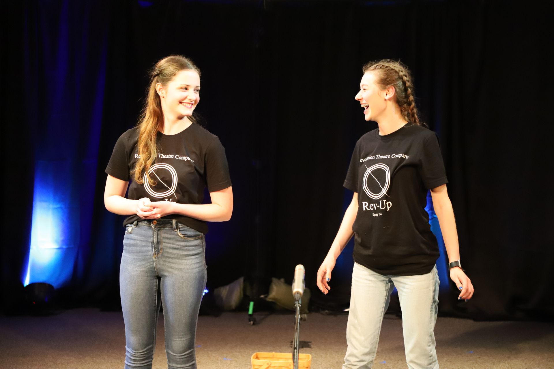 Two young women are standing next to each other on a stage.
