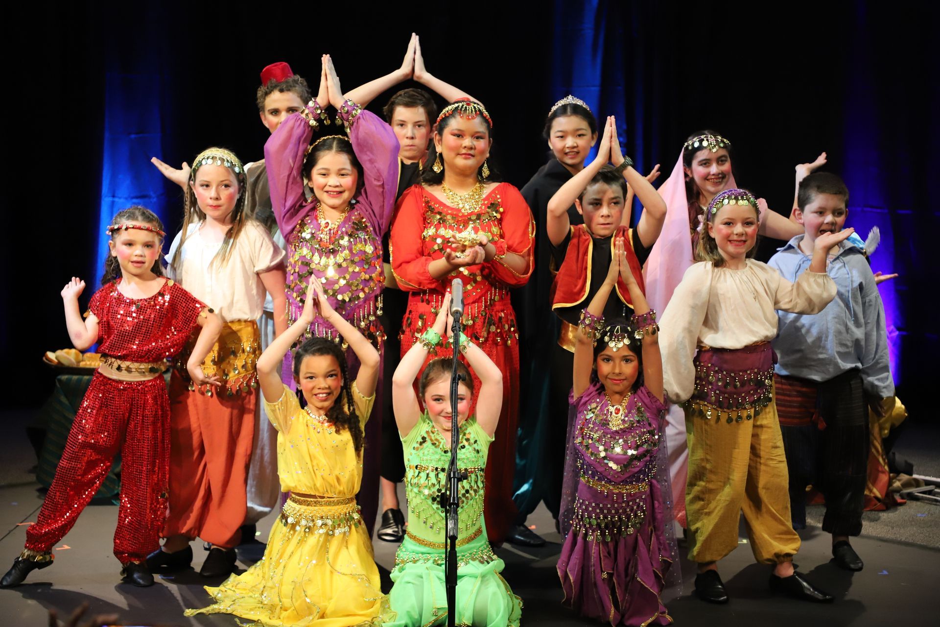 A group of children are posing for a picture on a stage.