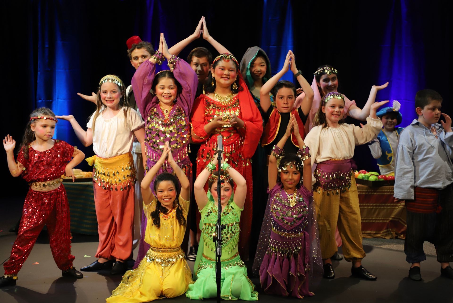 A group of children are posing for a picture on a stage.