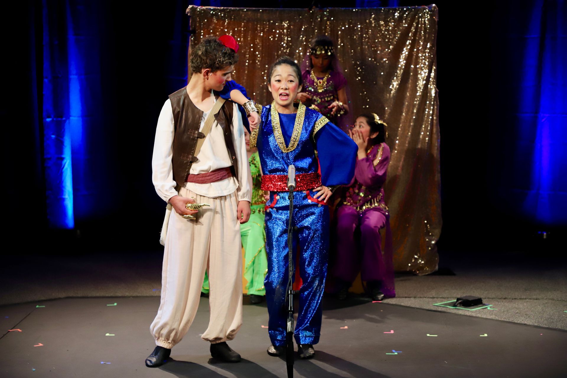 A man and a woman are standing next to each other on a stage.