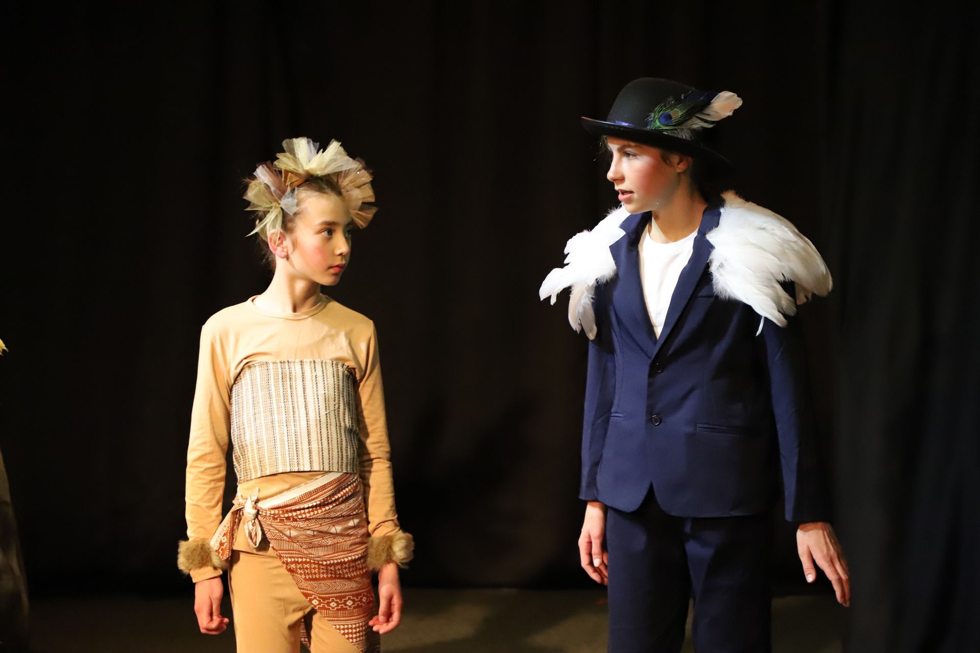 Two children are standing next to each other on a stage.