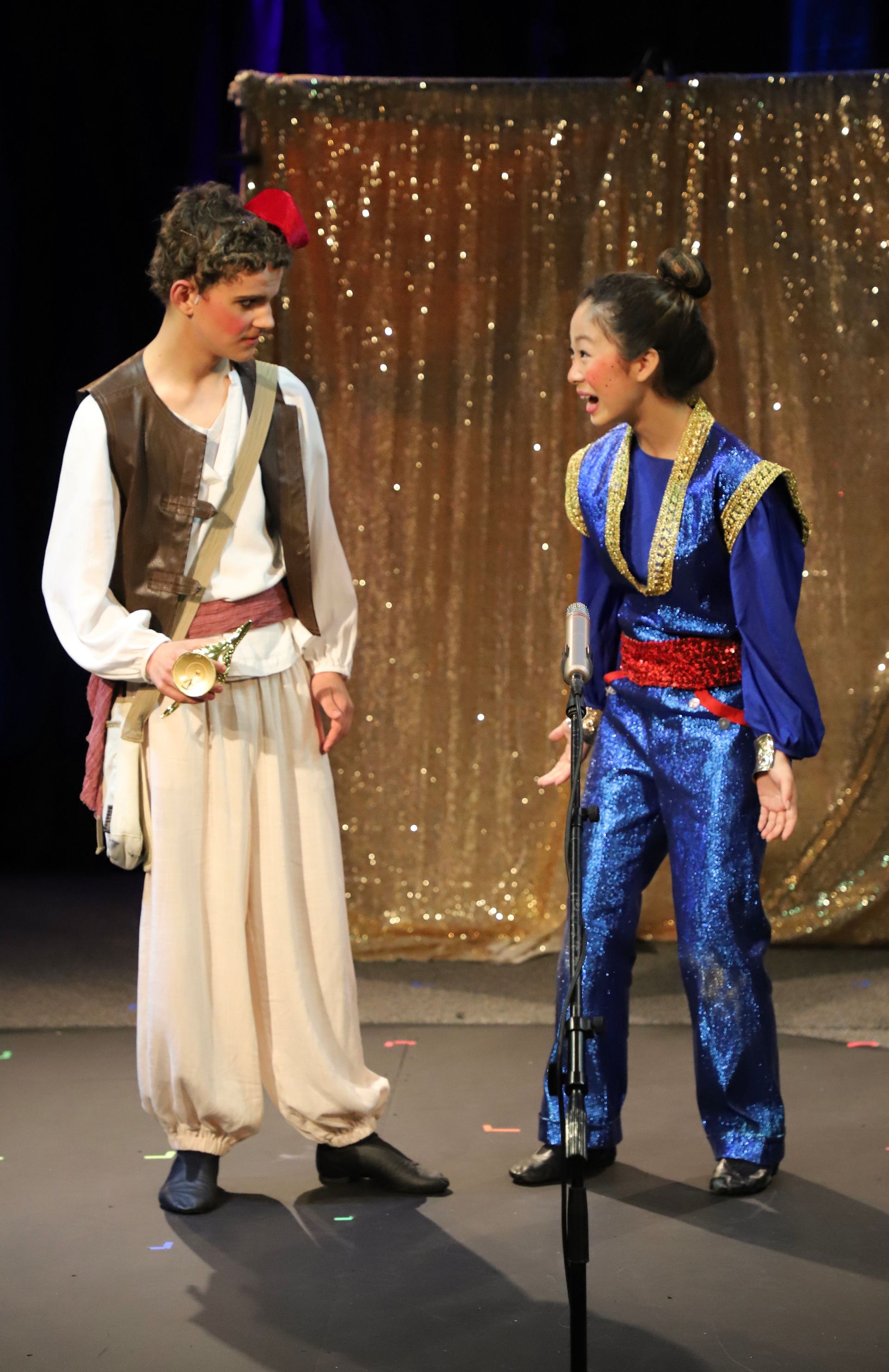 A man and a woman are standing next to each other on a stage.