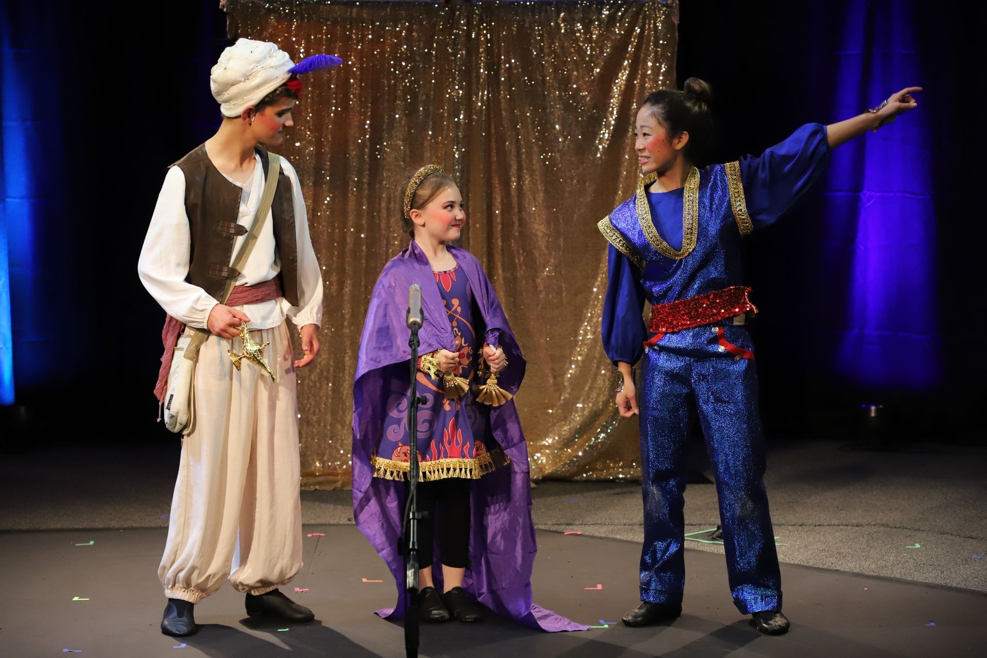 A group of people dressed in costumes are standing on a stage.