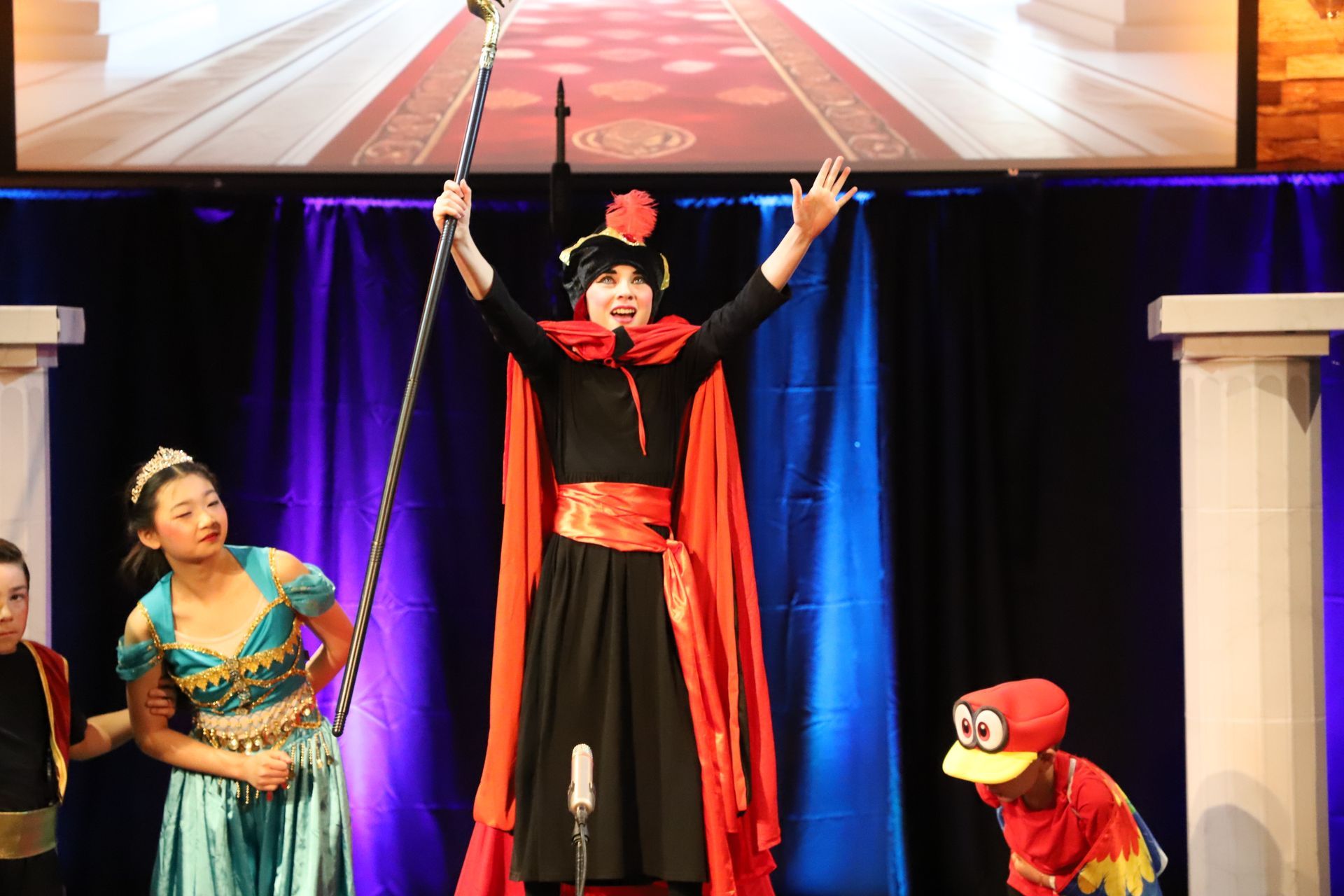 A group of people in costumes are standing on a stage.