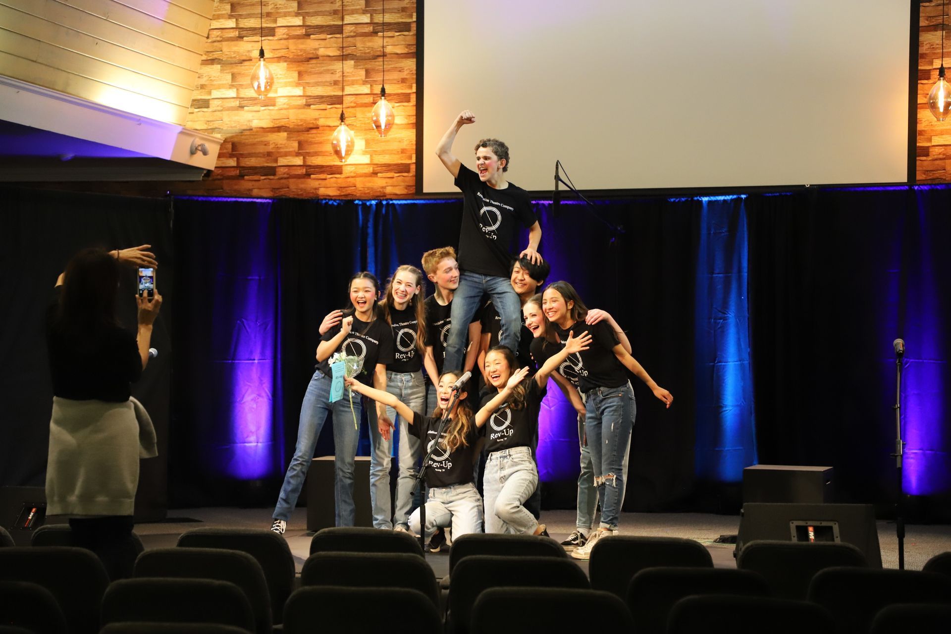 A group of children are posing for a picture on a stage.
