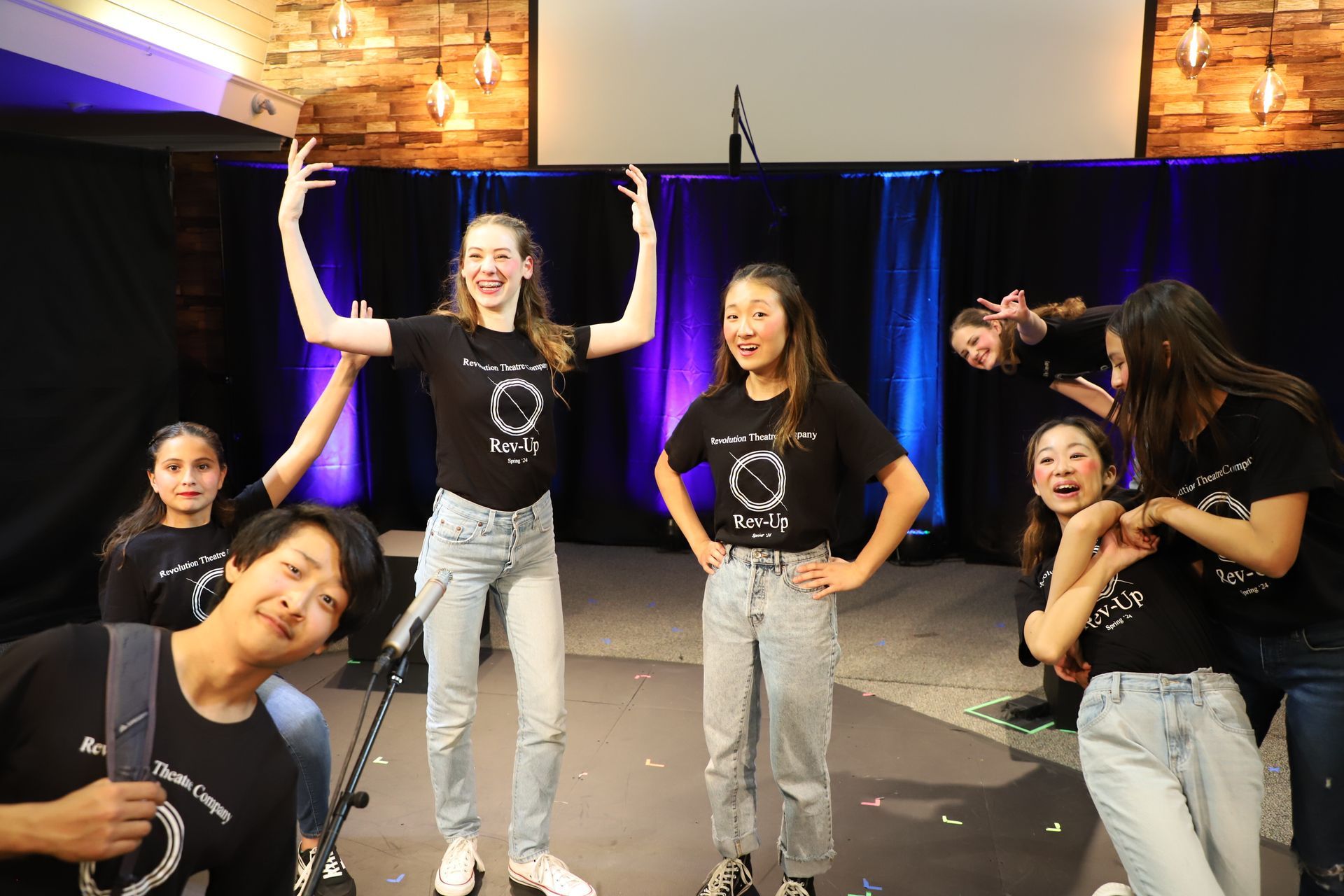 A group of young people are posing for a picture on a stage.