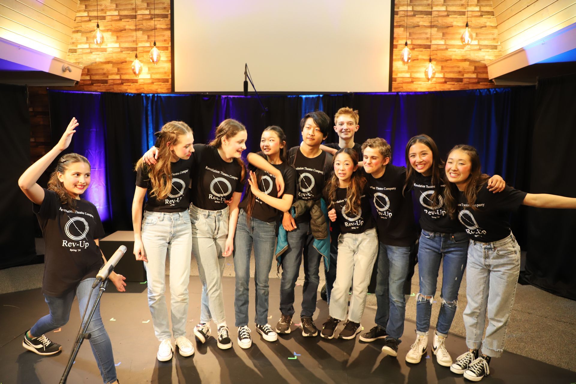 A group of young people are posing for a picture on a stage.